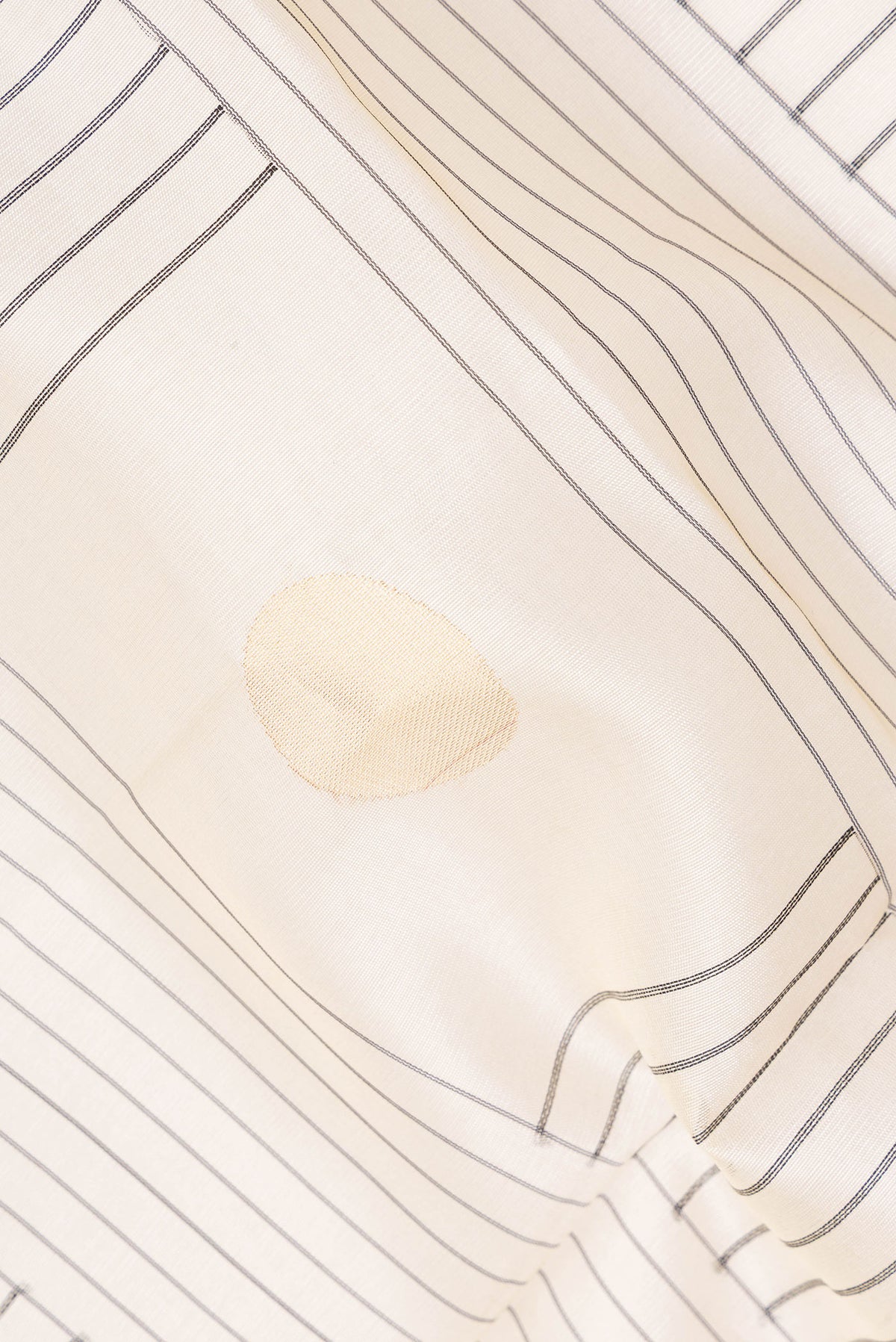 Close up of Cream Tussar Saree with Stripes on the body and Zari Border.  displaying folds