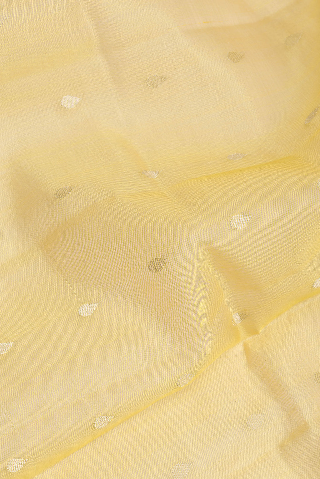Close up of Pure Silk Yellow Dual Tone Tussar Saree with Zari Butta on the body and Zari Border.  displaying folds