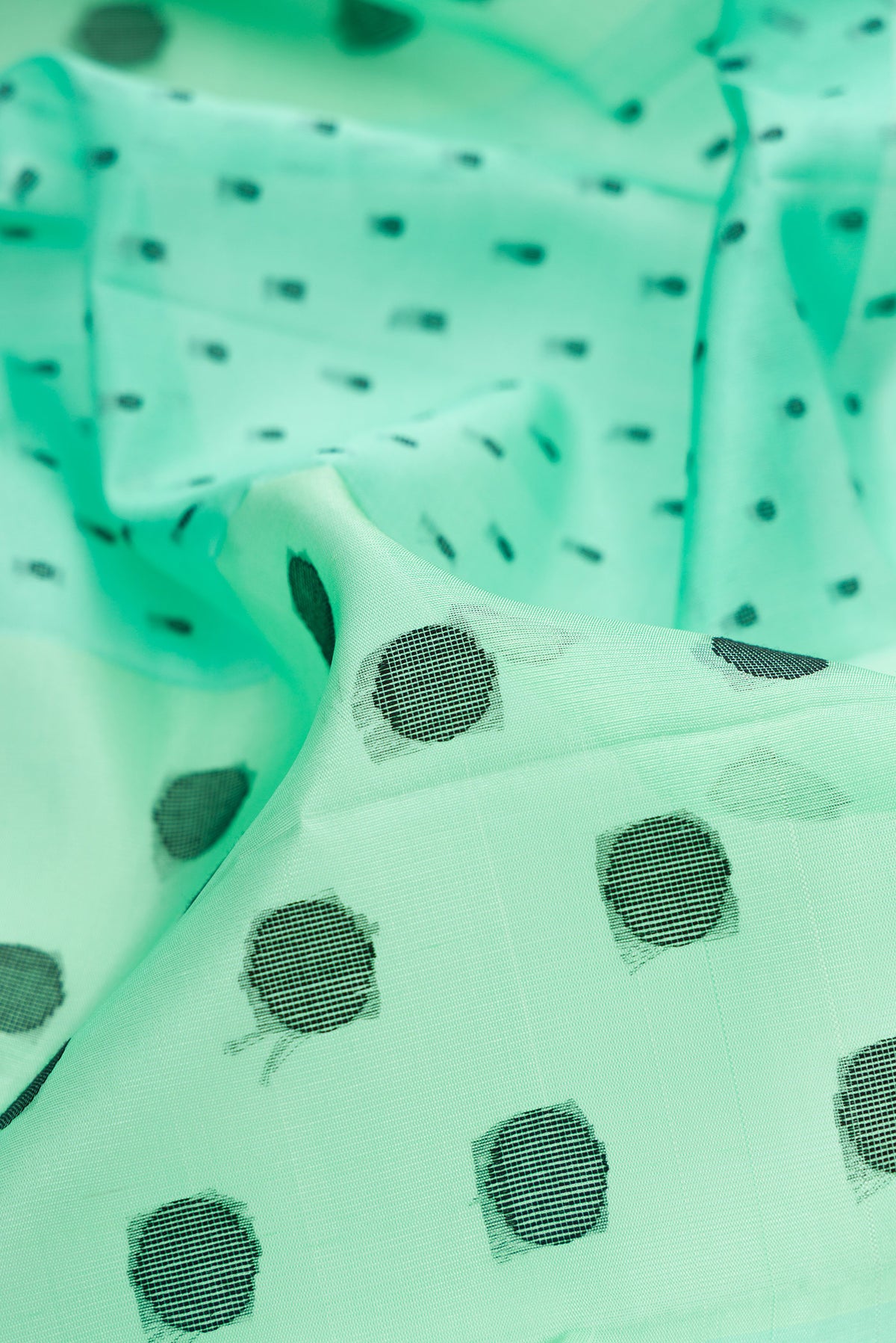 Close up of Pure Silk Sea Green Soft Saree with Thread Butta on the body and Without Border.  displaying folds