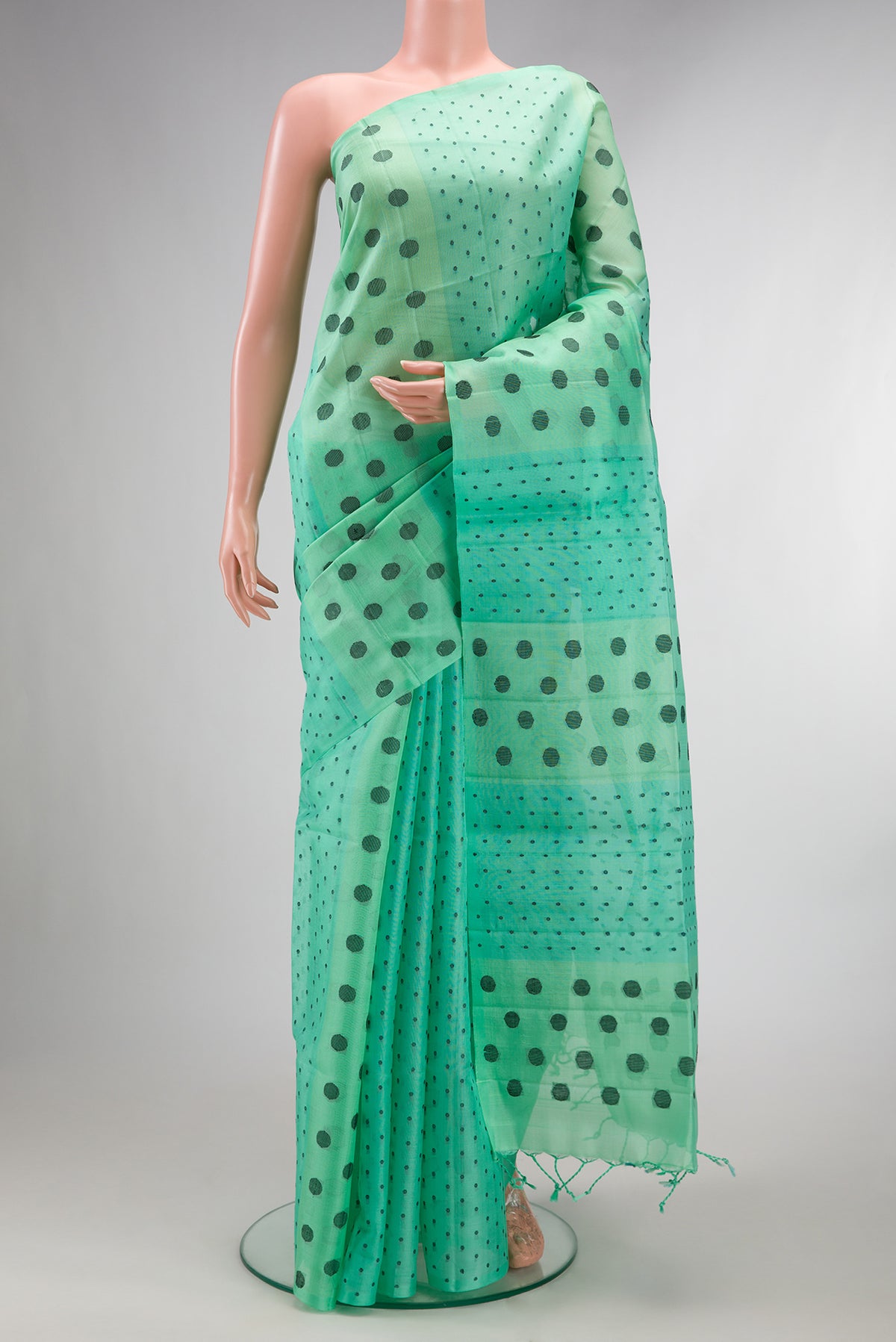 Pure Silk Sea Green Soft Saree with Thread Butta on the body and Without Border.  displayed on a mannequin