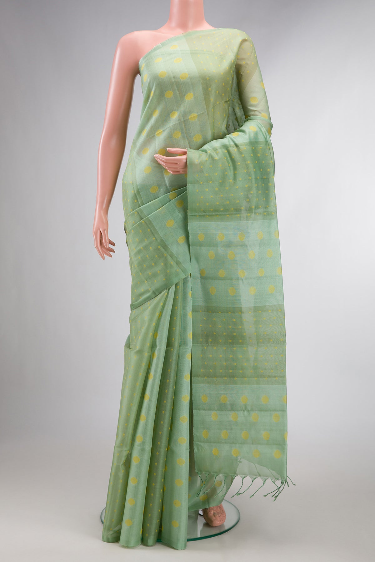 Pure Silk Pista Green Soft Saree with Thread Butta on the body and Without Border.  displayed on a mannequin