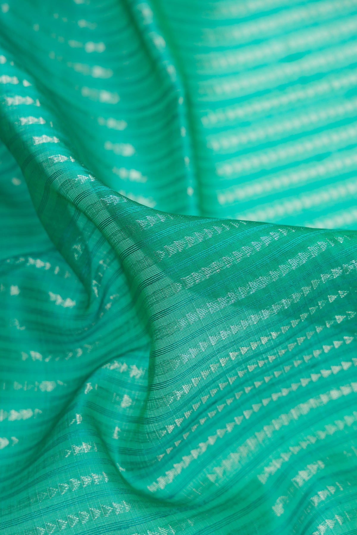 Close up of Green Dual Tone Organza Saree with Stripes on the body and Zari Border.  displaying folds