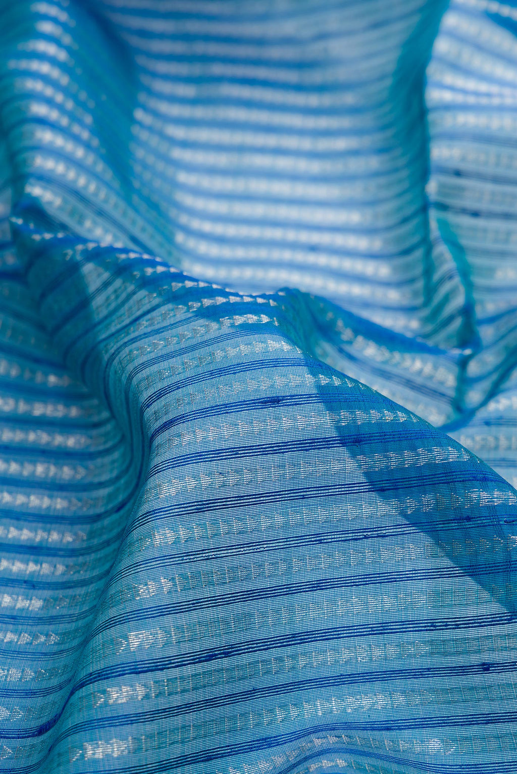 Close up of Peacock Blue Tussar Saree with Stripes on the body and Zari Border.  displaying folds