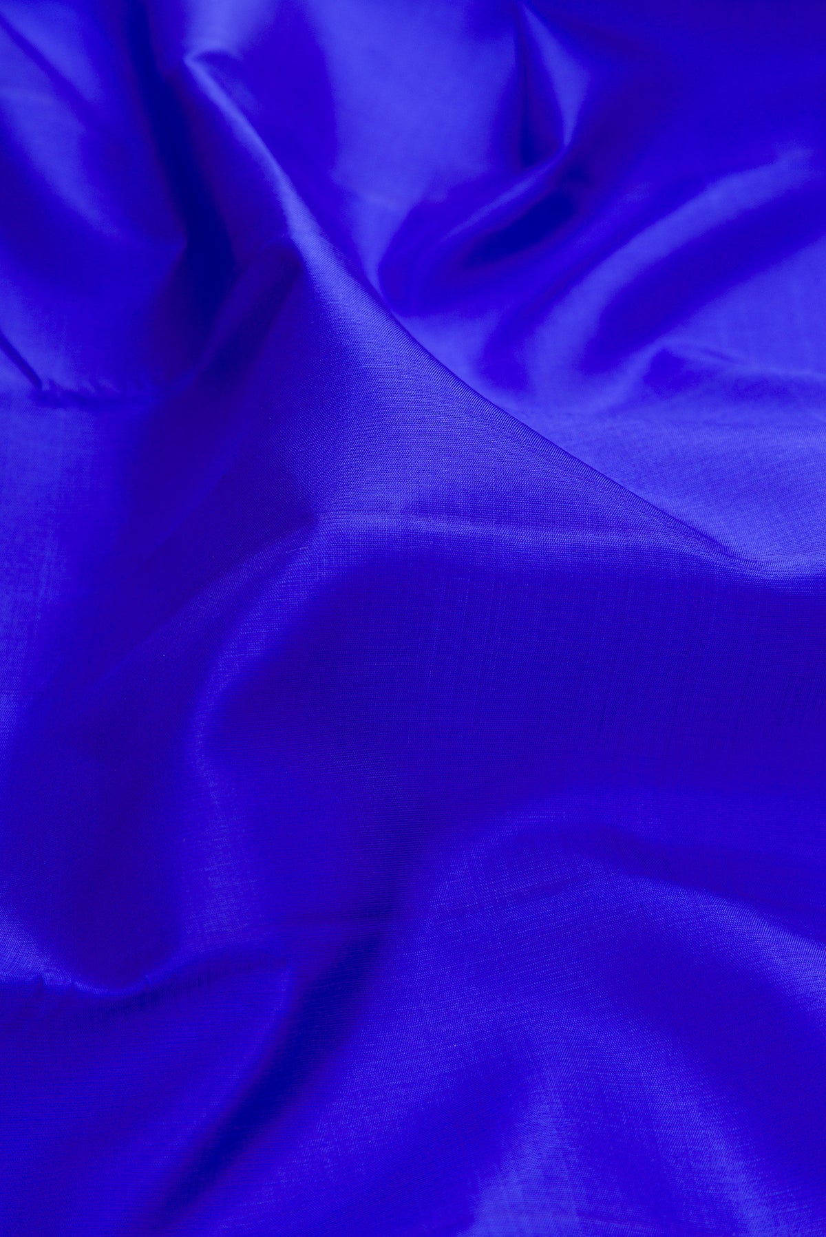 Close up of Pure Silk Royal Blue Kanjivaram Saree with Plain Body and Zari Border.  displaying folds