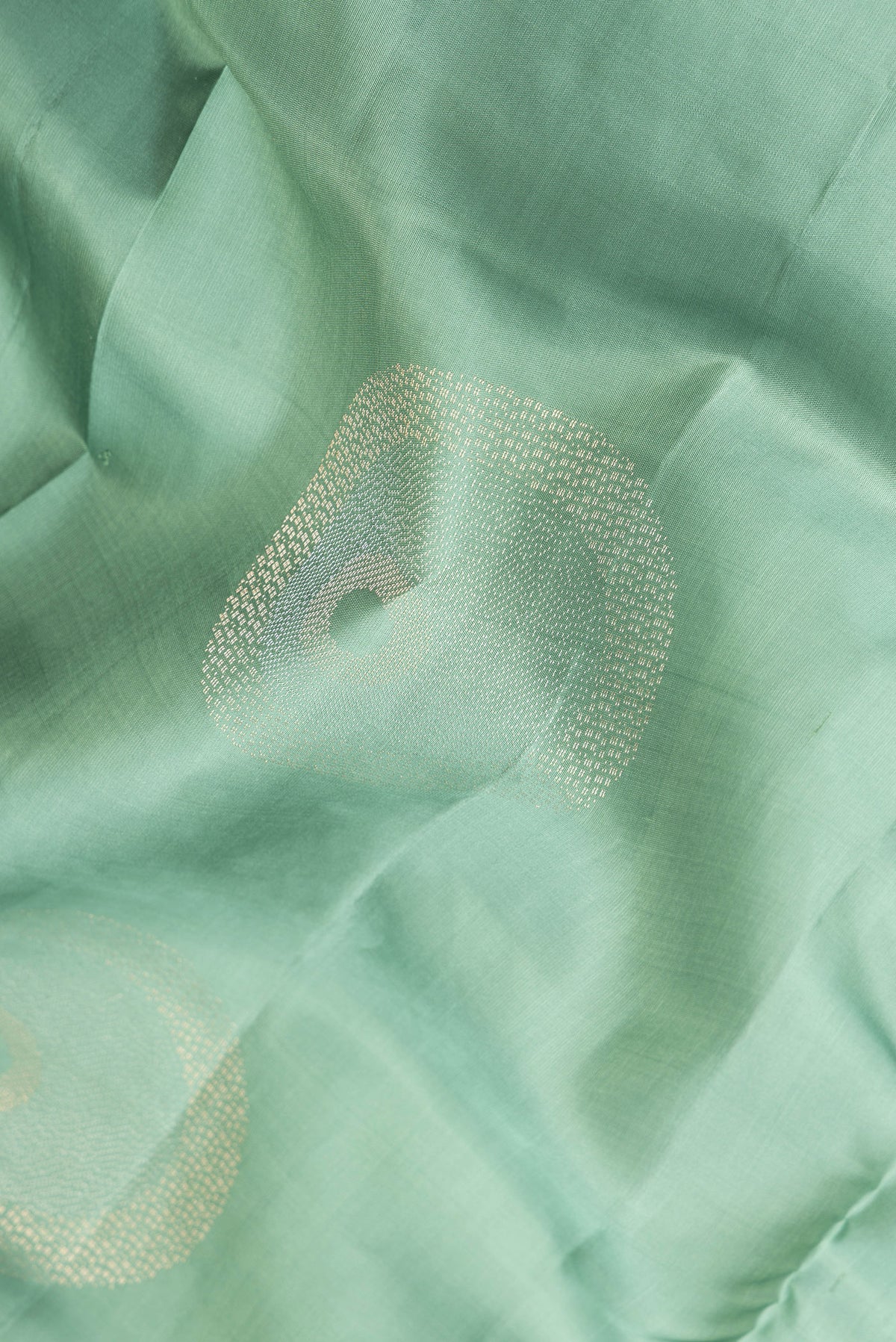 Close up of Pure Silk Green Dual Tone Soft Saree with Zari Butta on the body and Without Border.  displaying folds