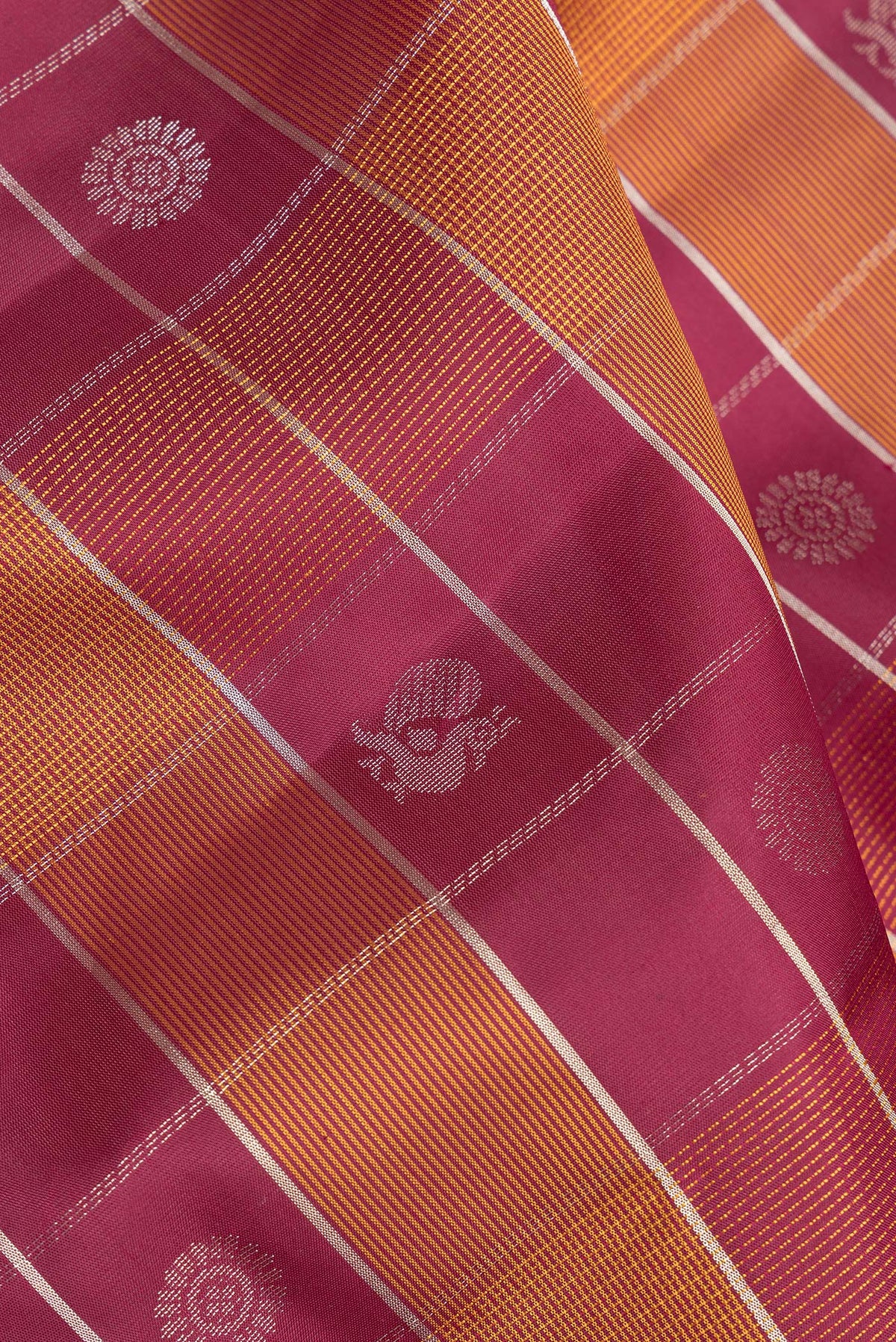 Close up of Pure Silk Maroon Dual Tone Soft Saree with Checked design on the body and Zari Border.  displaying folds