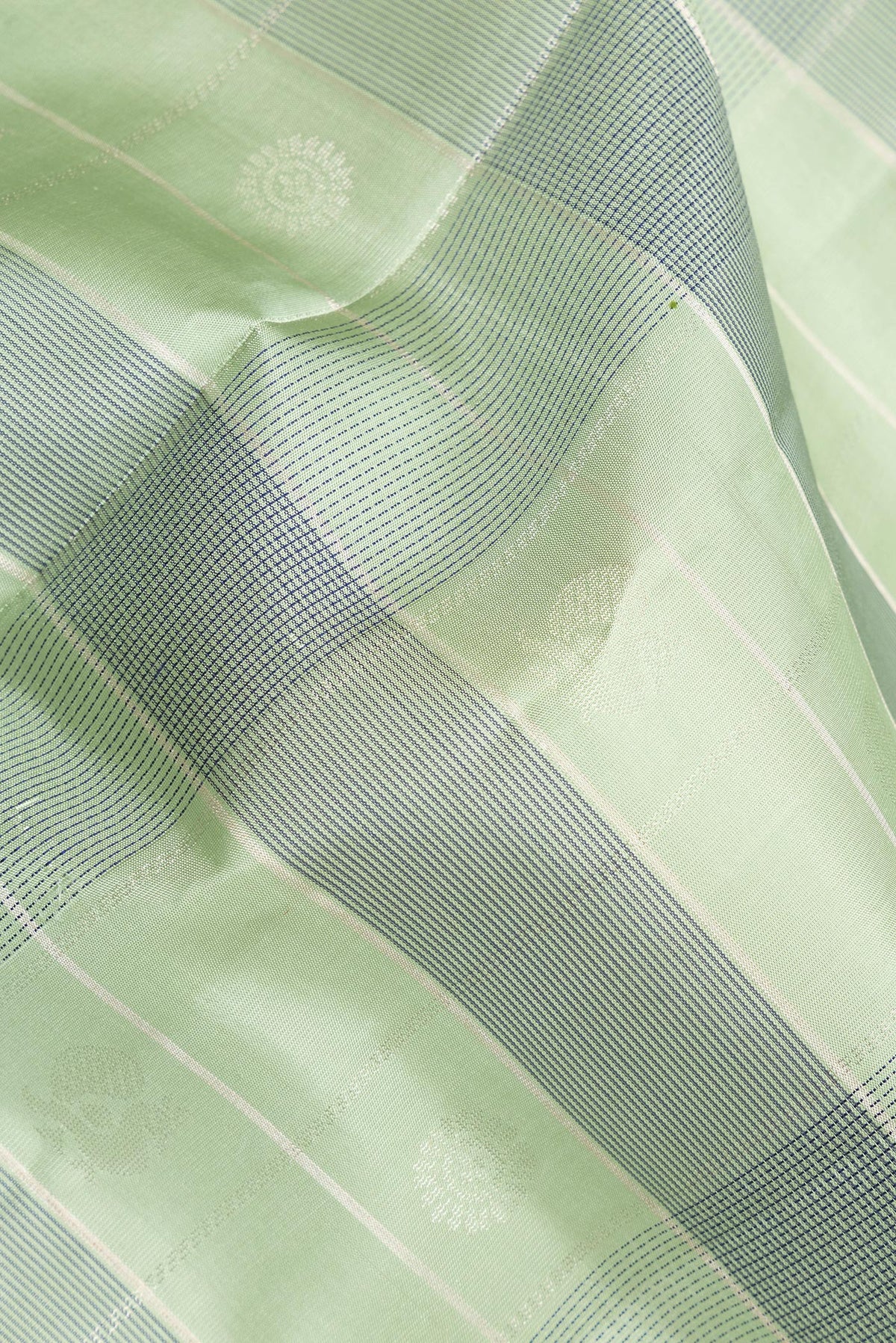 Close up of Pure Silk Pista Green Dual Tone Soft Saree with Checked design on the body and Zari Border.  displaying folds