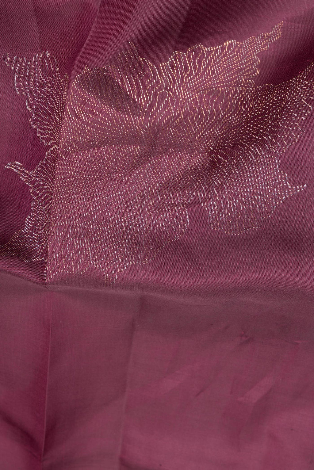 Close up of Pure Silk Burgundy Dual Tone Soft Saree with Zari Butta on the body and Without Border.  displaying folds