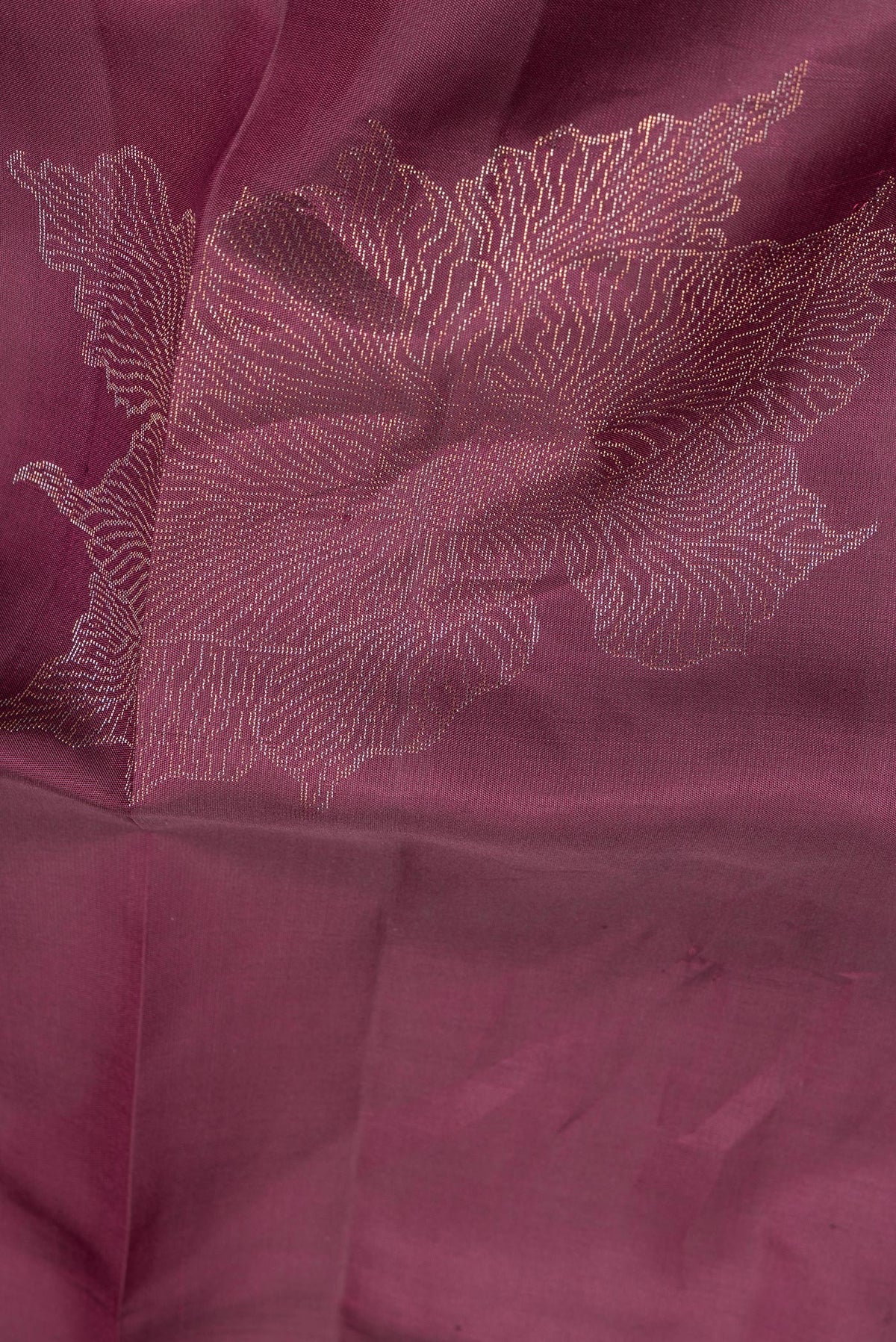 Close up of Pure Silk Burgundy Dual Tone Soft Saree with Zari Butta on the body and Without Border.  displaying folds