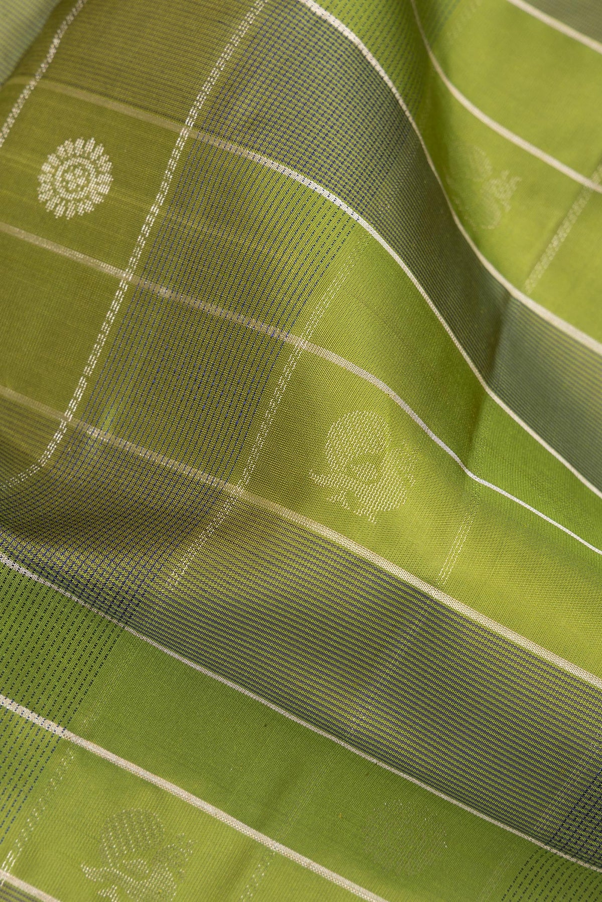 Close up of Pure Silk Mehandi Green Dual Tone Soft Saree with Checked design on the body and Zari Border.  displaying folds