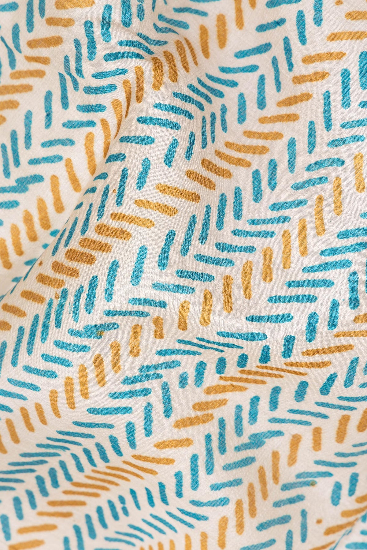 Close up of Beige Tussar Saree with Printed design on the body and Printed Border.  displaying folds