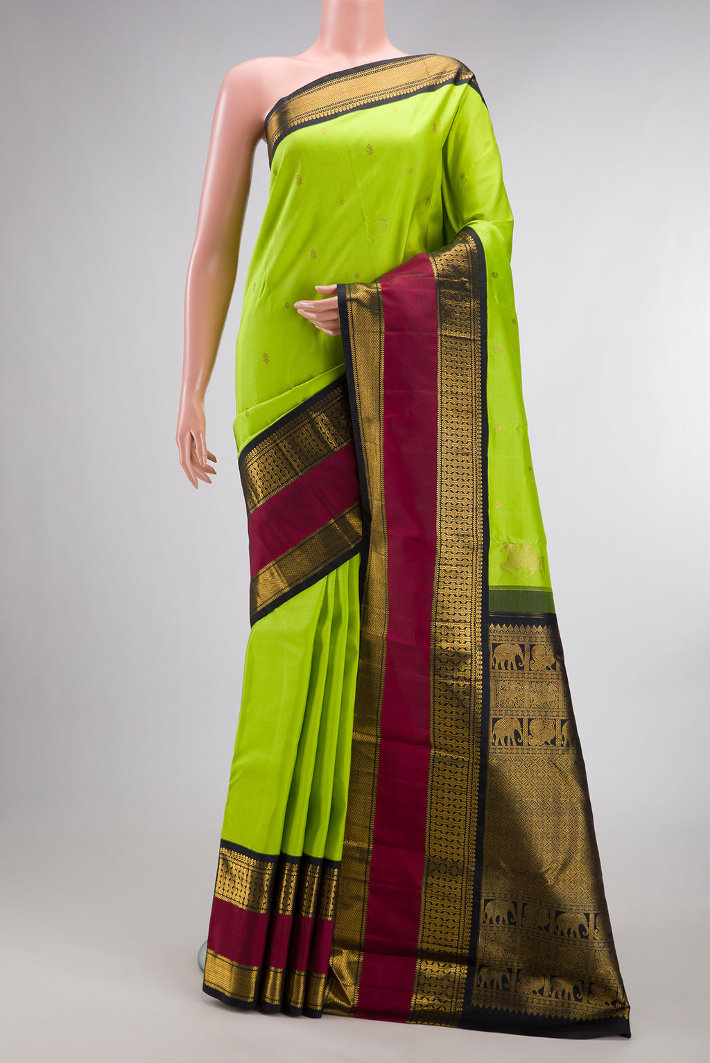 Pure Silk Parrot Green Kanchipuram Saree with Zari Butta on the body and Zari Border.  displayed on a mannequin