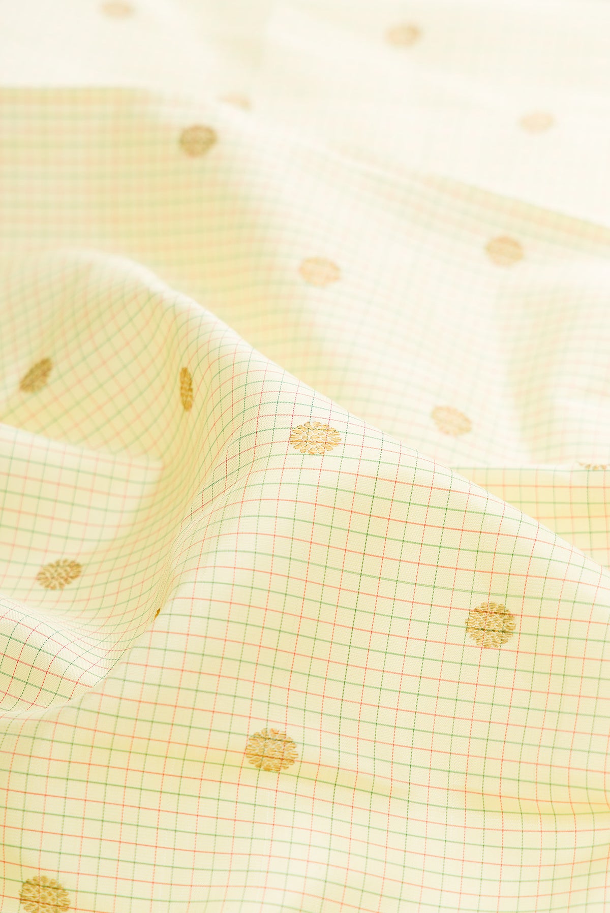 Close up of Pure Silk Cream Kanjivaram Saree with Checked design on the body and Zari Border.  displaying folds