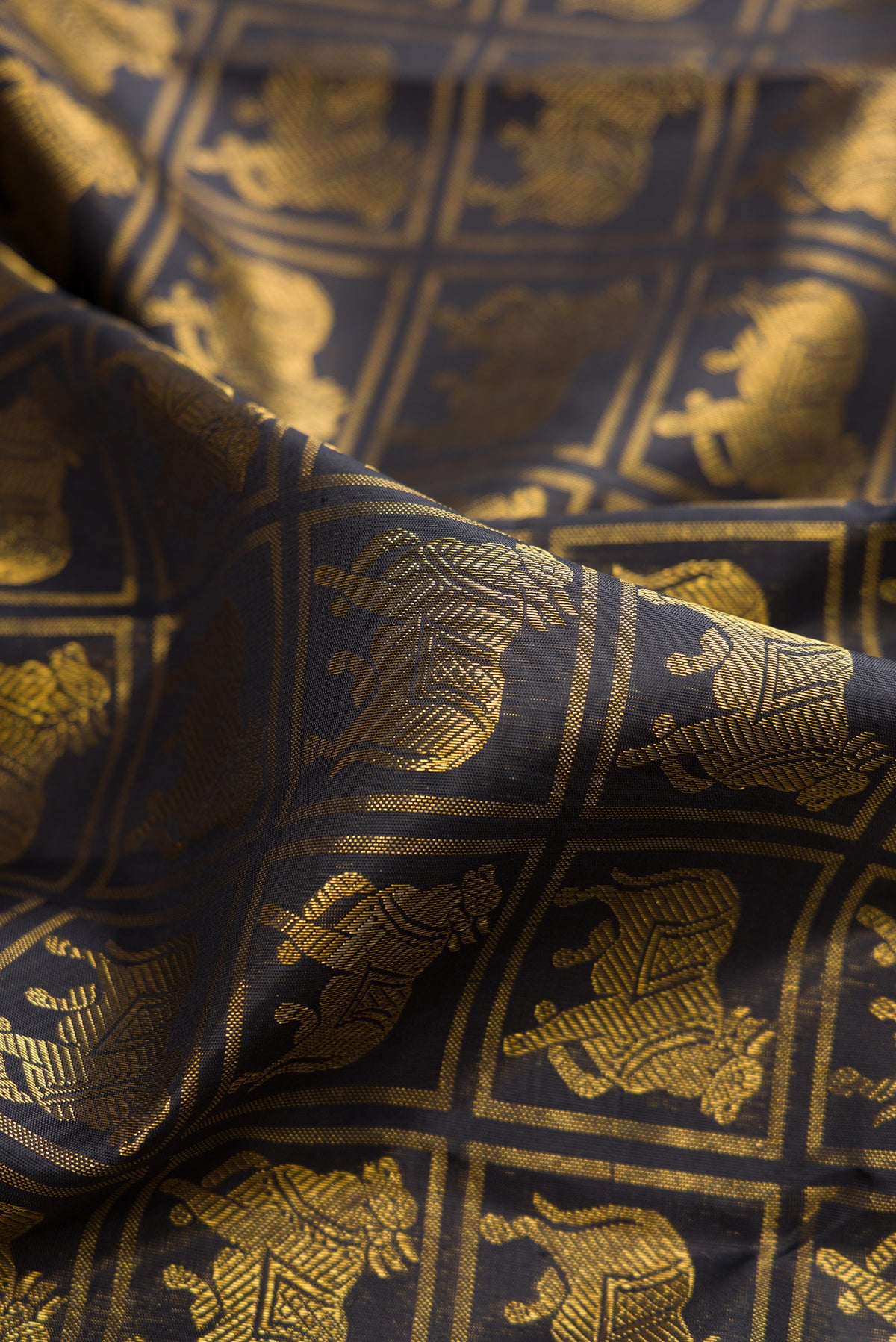 Close up of Pure Silk Black Dual Tone Kanchipuram Saree with Checked design on the body and Zari Border.  displaying folds