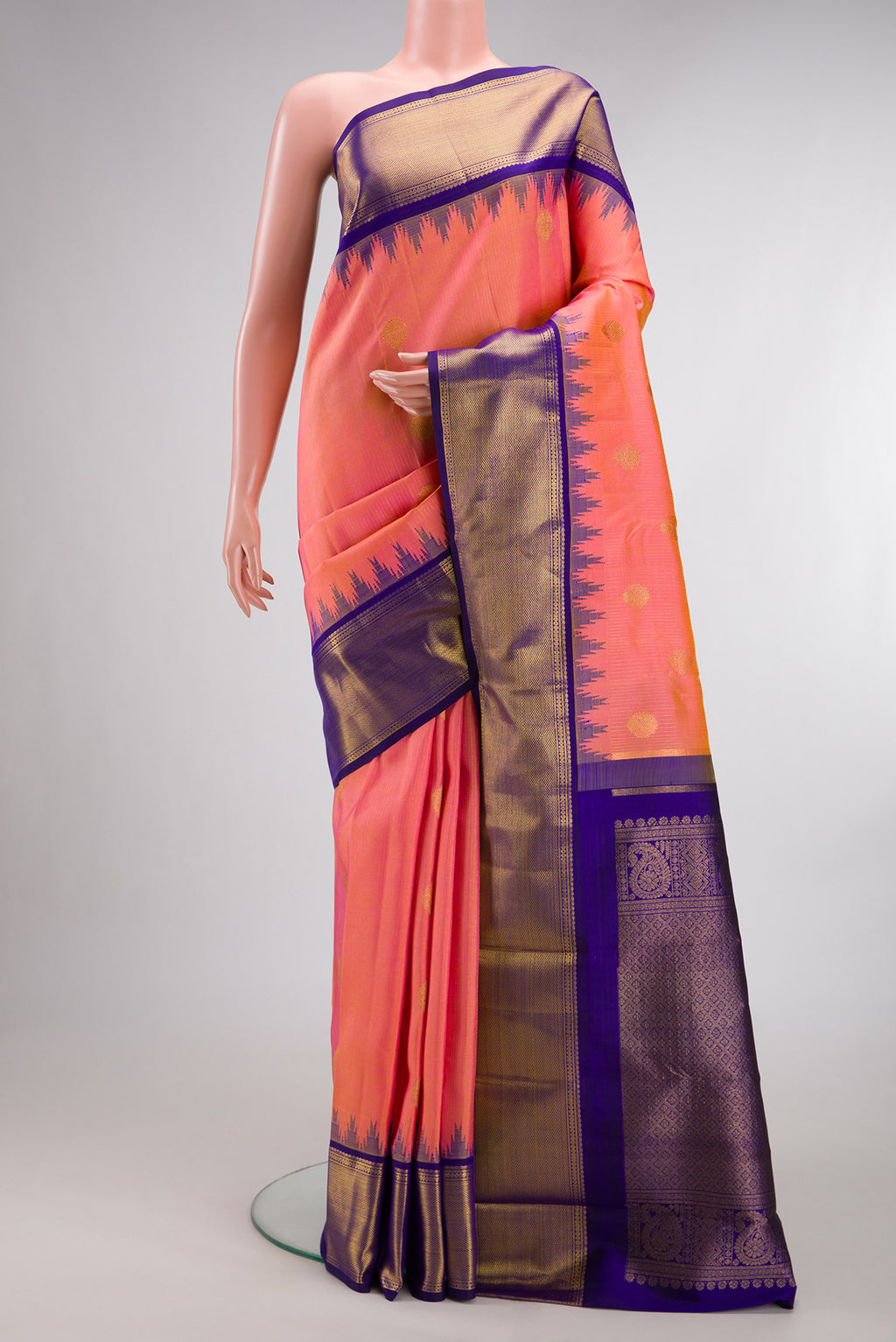 Pure Silk Peach Kanchipuram Saree with Zari Butta on the body and Temple Border.  displayed on a mannequin