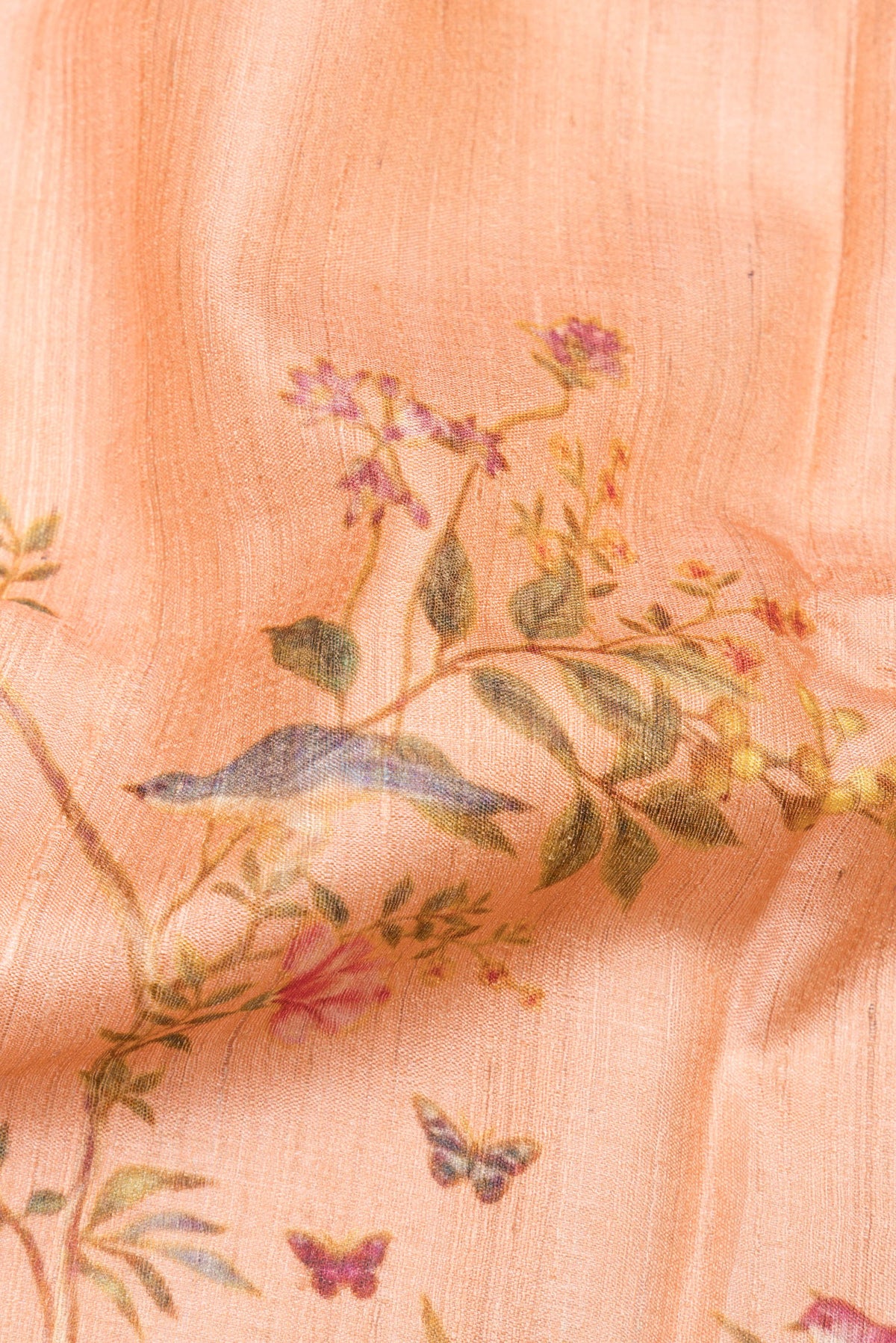 Close up of Peach Tussar Saree with Printed design on the body and Zari Border.  displaying folds