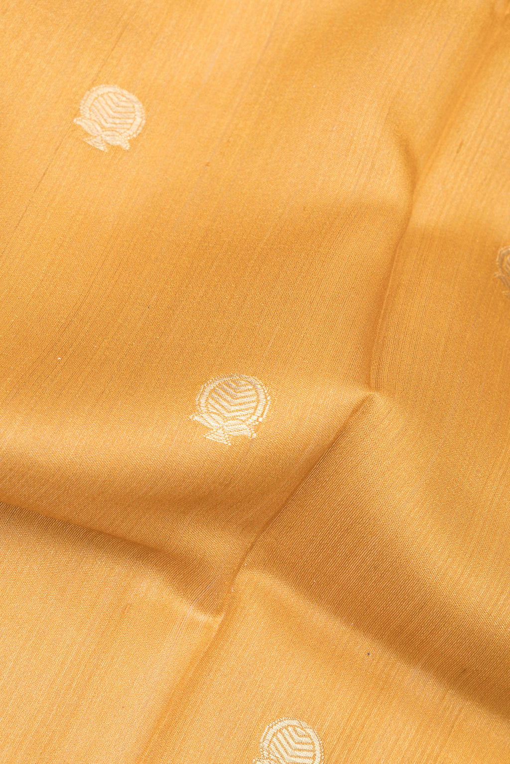 Close up of Mustard Tussar Saree with Zari Butta on the body and Fancy Border.  displaying folds