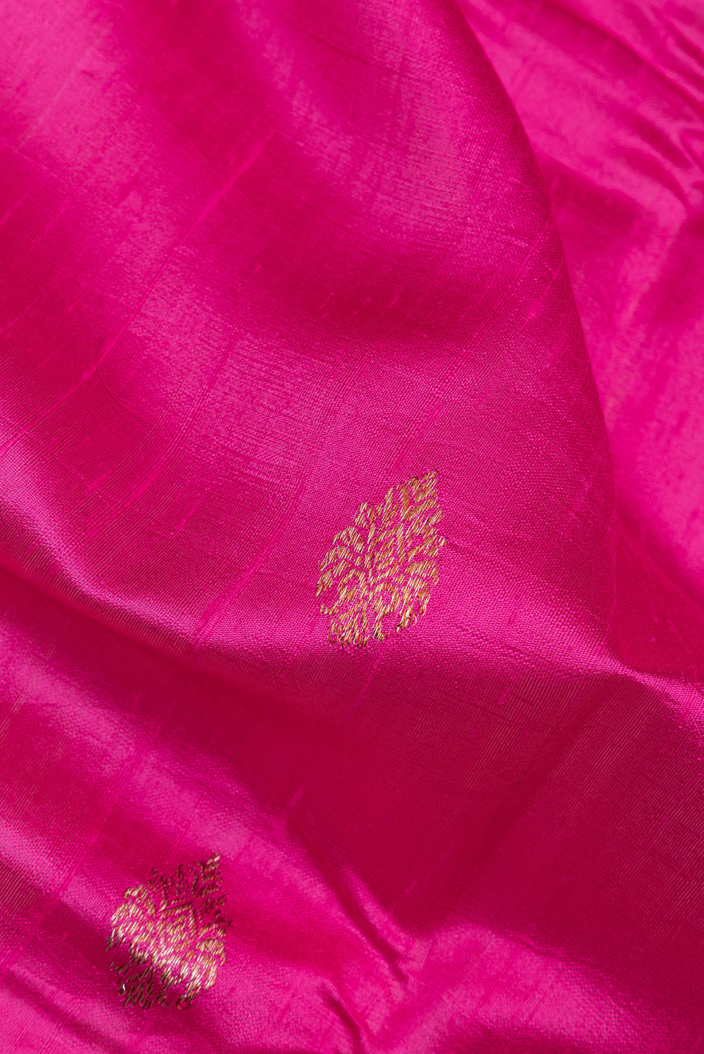 Close up of Dark Pink Raw Saree with Zari Butta on the body and Zari Border.  displaying folds