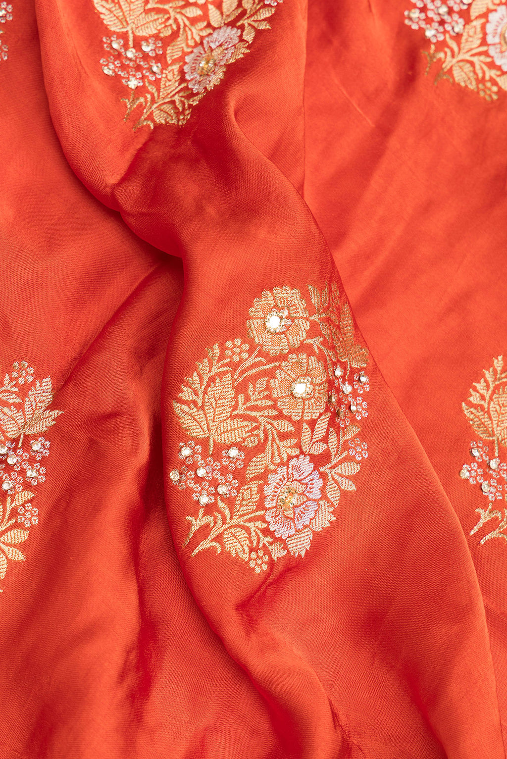 Close up of Orange Satin Saree with Embroidered on the body and Sequin Border.  displaying folds