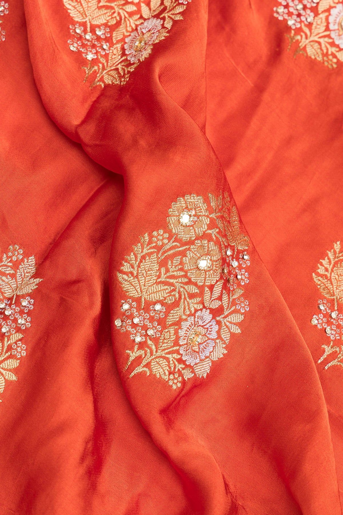 Close up of Orange Satin Saree with Embroidered on the body and Sequin Border.  displaying folds