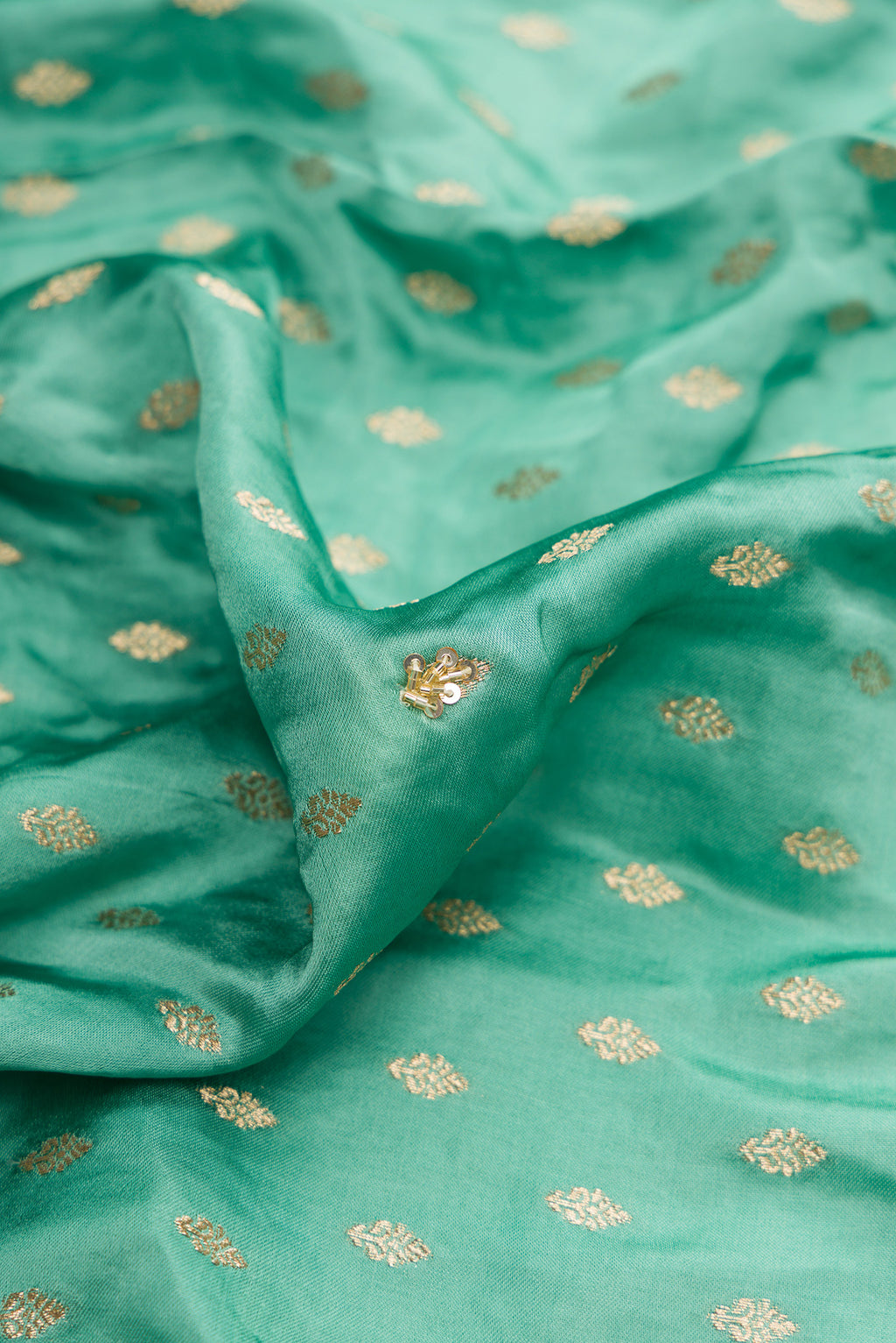 Close up of Sea Green Satin Crepe Saree with Embroidered on the body and Sequin Border.  displaying folds