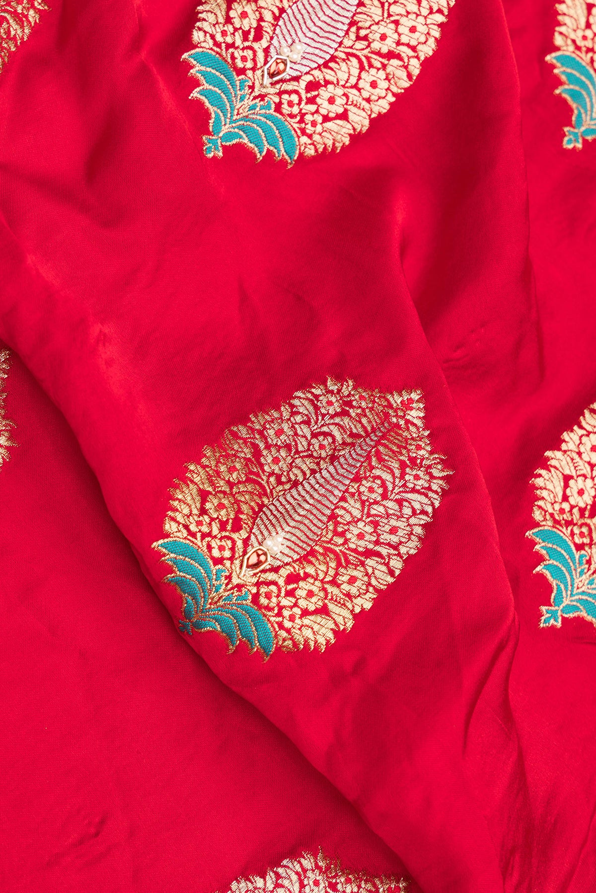 Close up of Red Satin Saree with Embroidered on the body and Sequin Border.  displaying folds