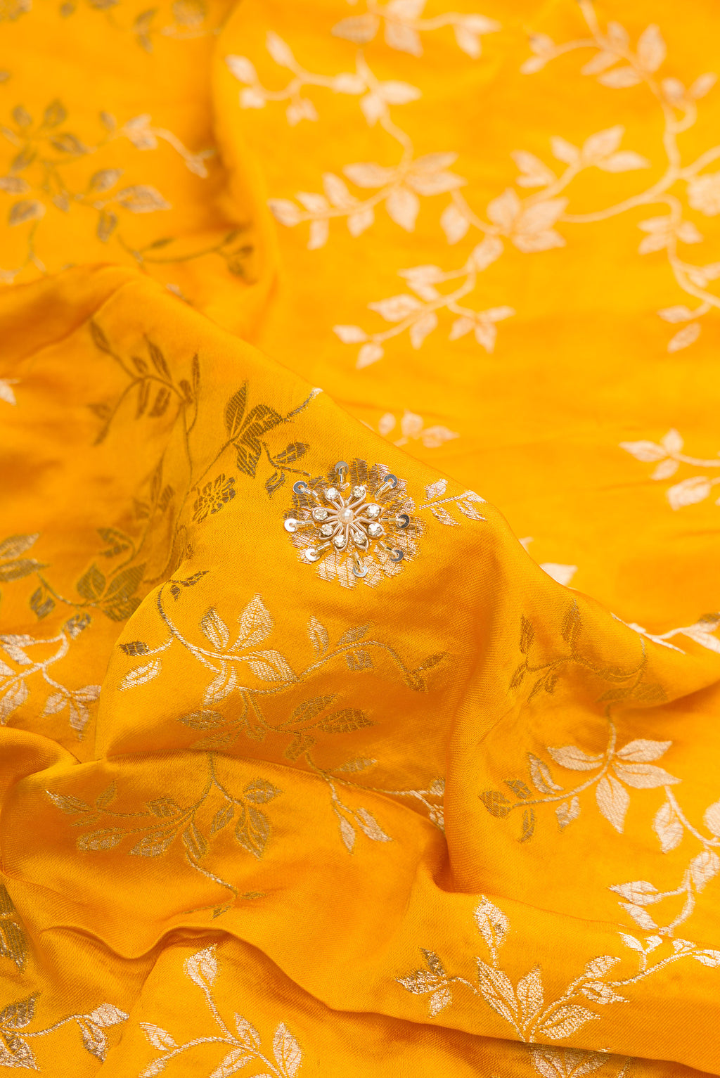 Close up of Yellow Satin Crepe Saree with Embroidered on the body and Sequin Border.  displaying folds