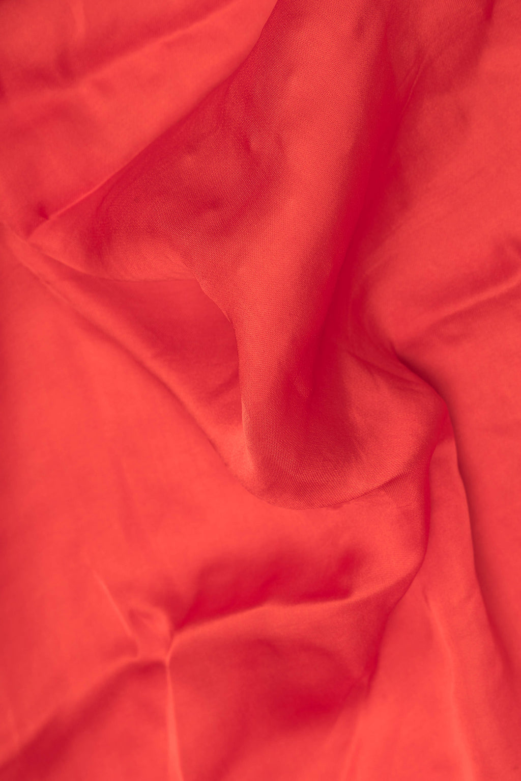 Close up of Orange Satin Saree with Plain Body and Sequin Border.  displaying folds
