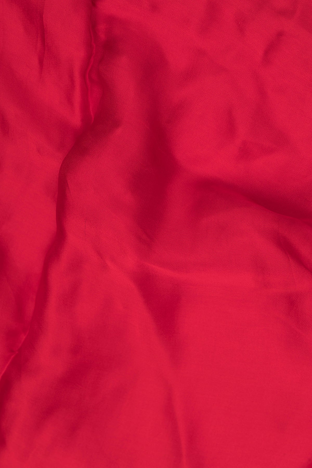 Close up of Red Satin Saree with Embroidered on the body and Sequin Border.  displaying folds