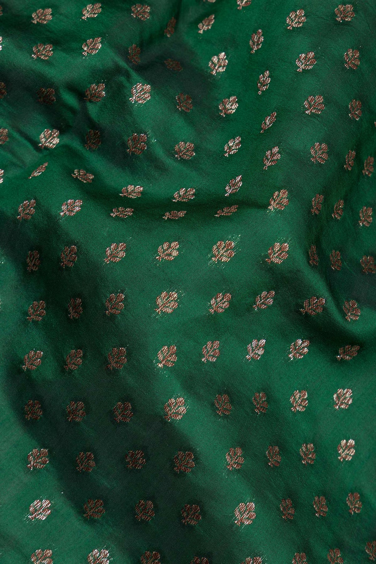 Close up of Pure Silk Bottle Green Tussar Saree with Zari Butta on the body and Zari Border.  displaying folds