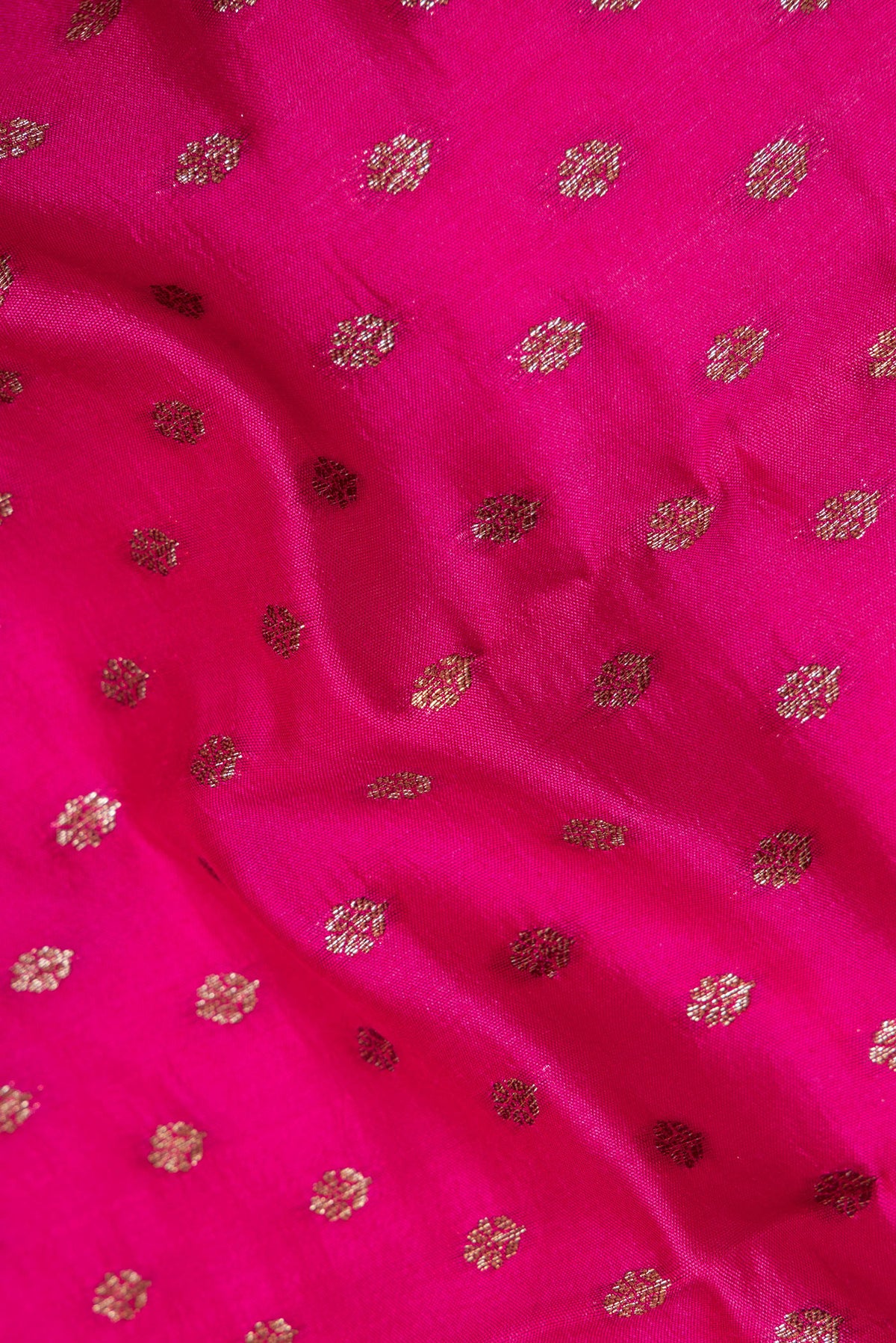 Close up of Pure Silk Dark Pink Tussar Saree with Zari Butta on the body and Zari Border.  displaying folds