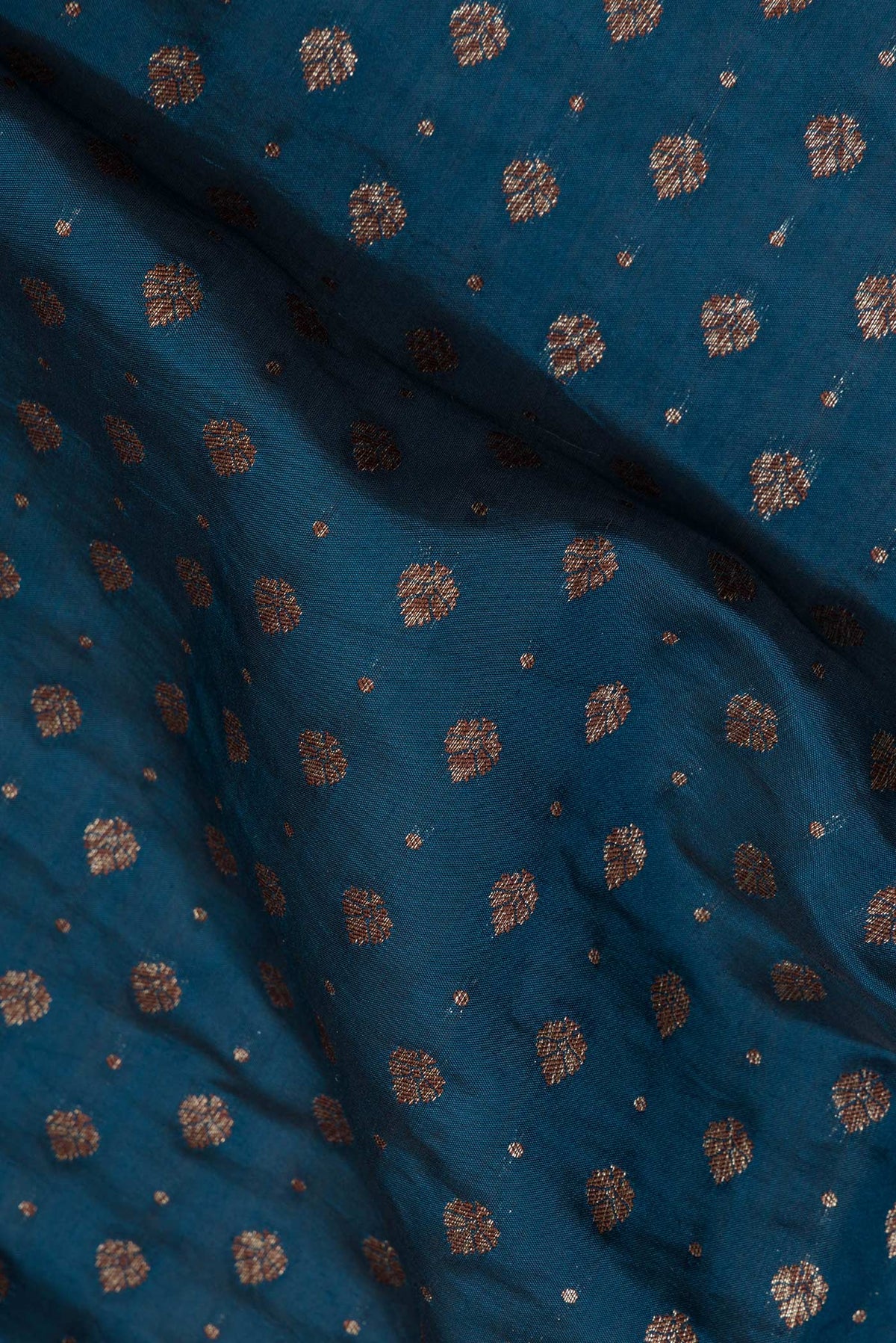 Close up of Pure Silk Teal Tussar Saree with Zari Butta on the body and Zari Border.  displaying folds