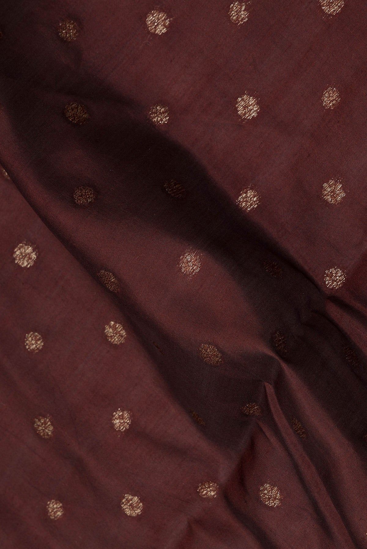 Close up of Pure Silk Brown Tussar Saree with Zari Butta on the body and Zari Border.  displaying folds