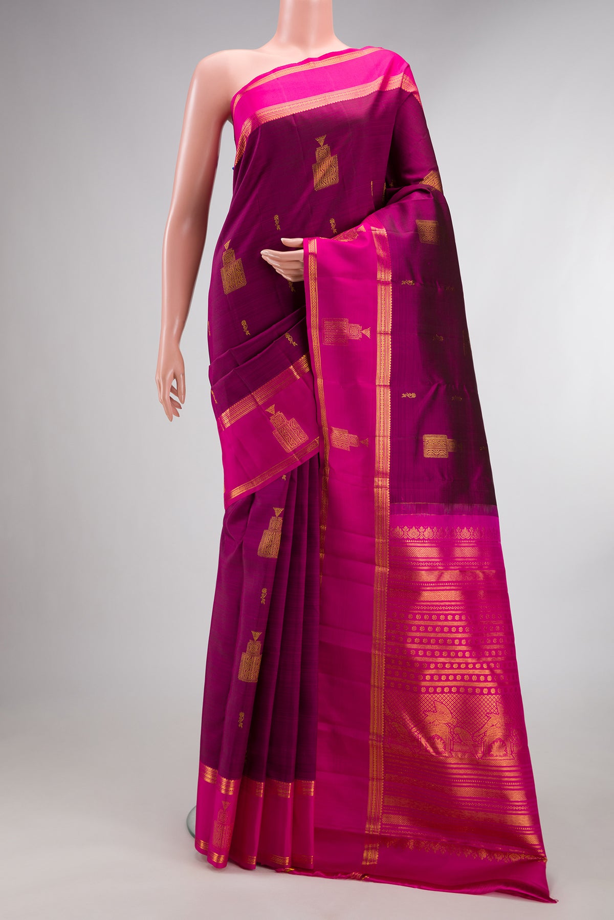 Pure Silk Magenta Kanjivaram Saree with Zari Butta on the body and Zari Border.  displayed on a mannequin