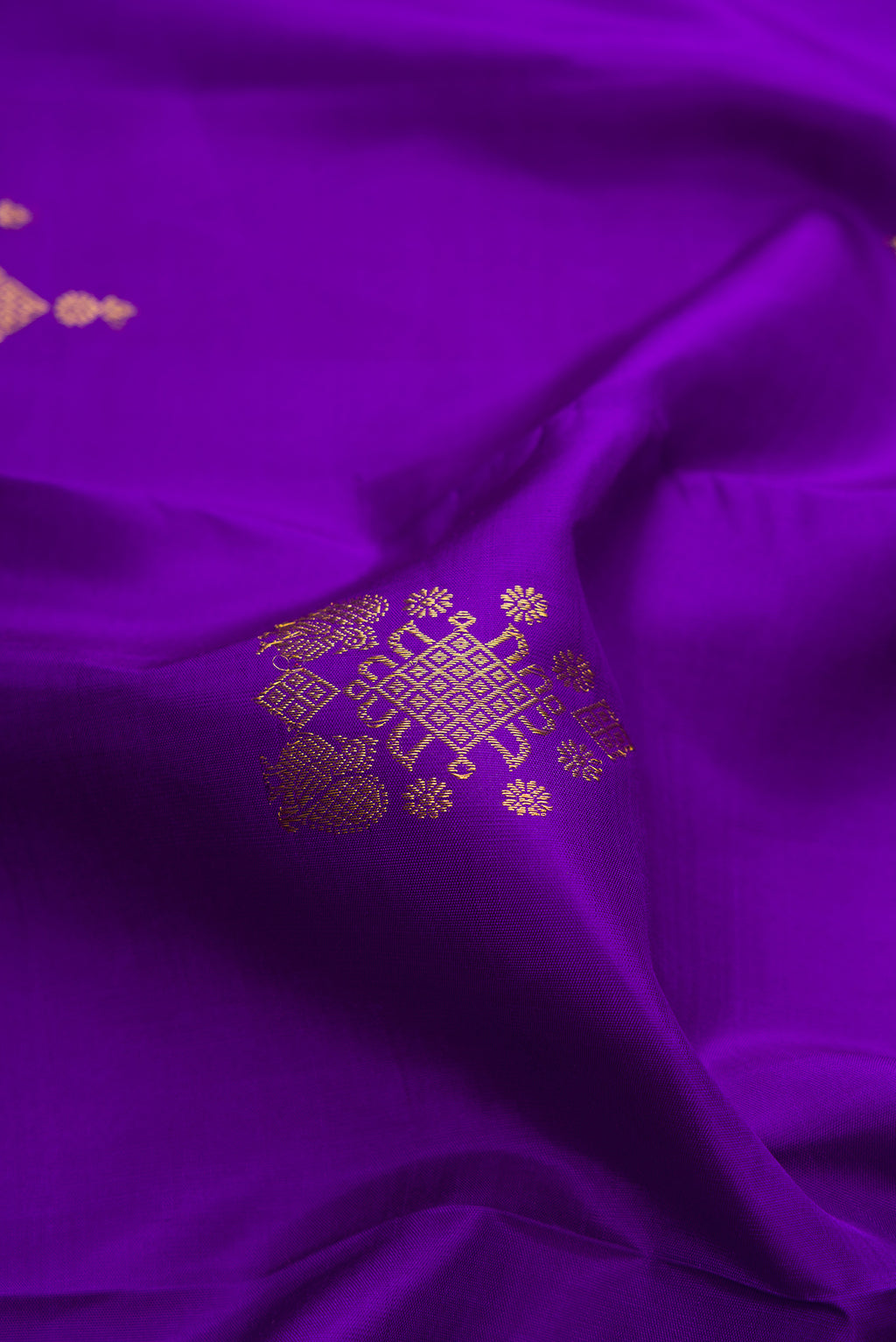 Close up of Pure Silk Violet Kanjivaram Saree with Zari Butta on the body and Zari Border.  displaying folds