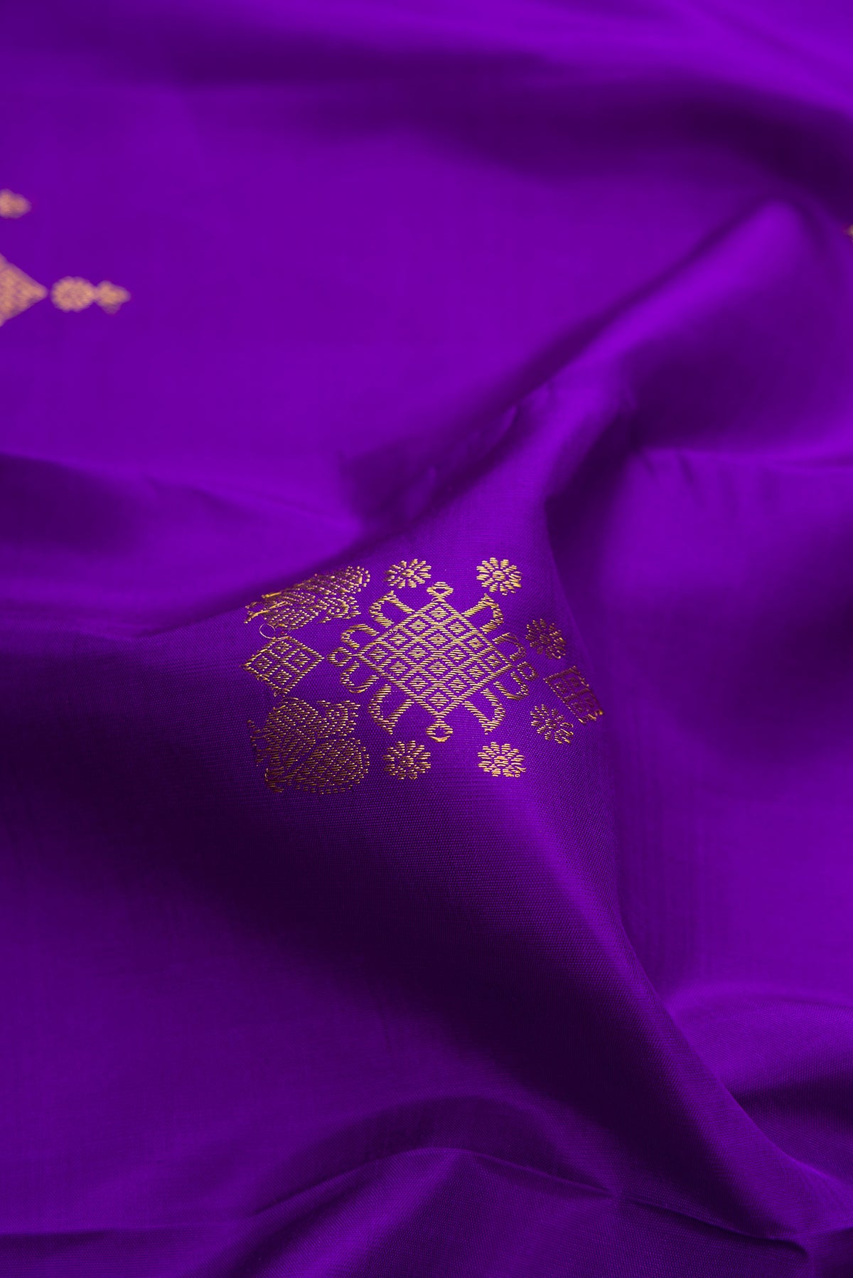 Close up of Pure Silk Violet Kanjivaram Saree with Zari Butta on the body and Zari Border.  displaying folds