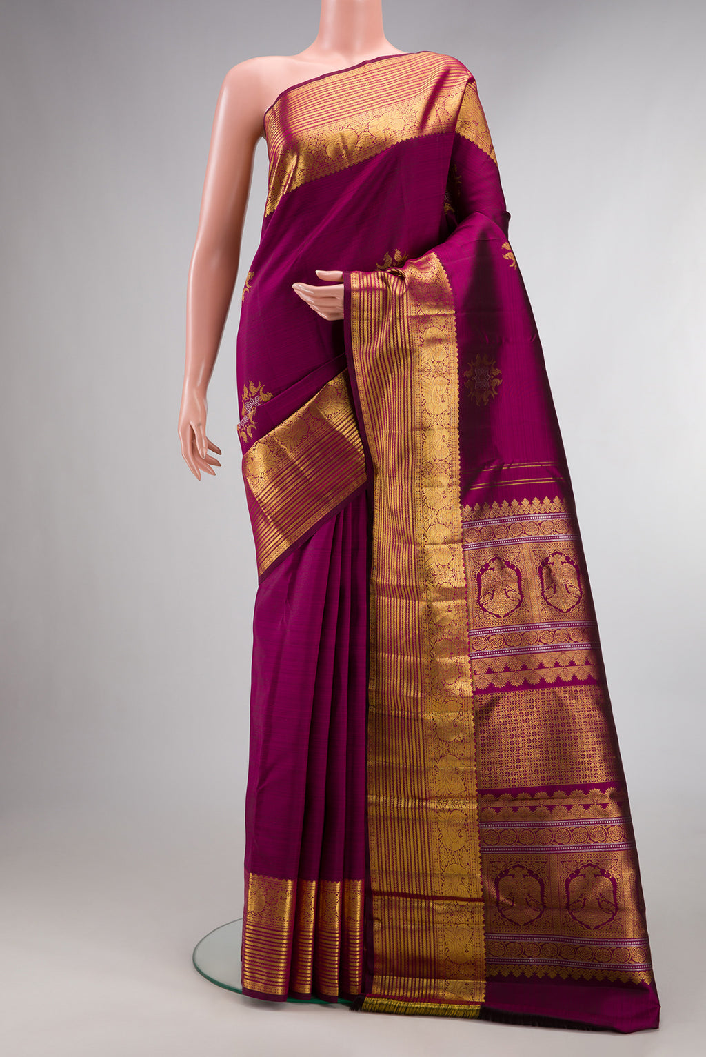 Pure Silk Magenta Kanjivaram Saree with Zari Butta on the body and Zari Border.  displayed on a mannequin