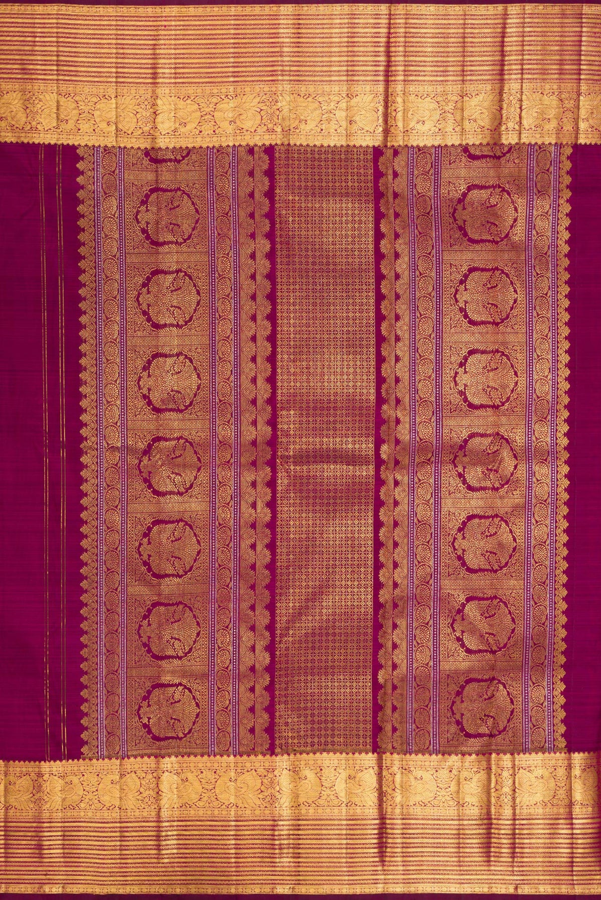 Close up image of the pallu of Pure Silk Magenta Kanjivaram Saree with Zari Butta on the body and Zari Border. 