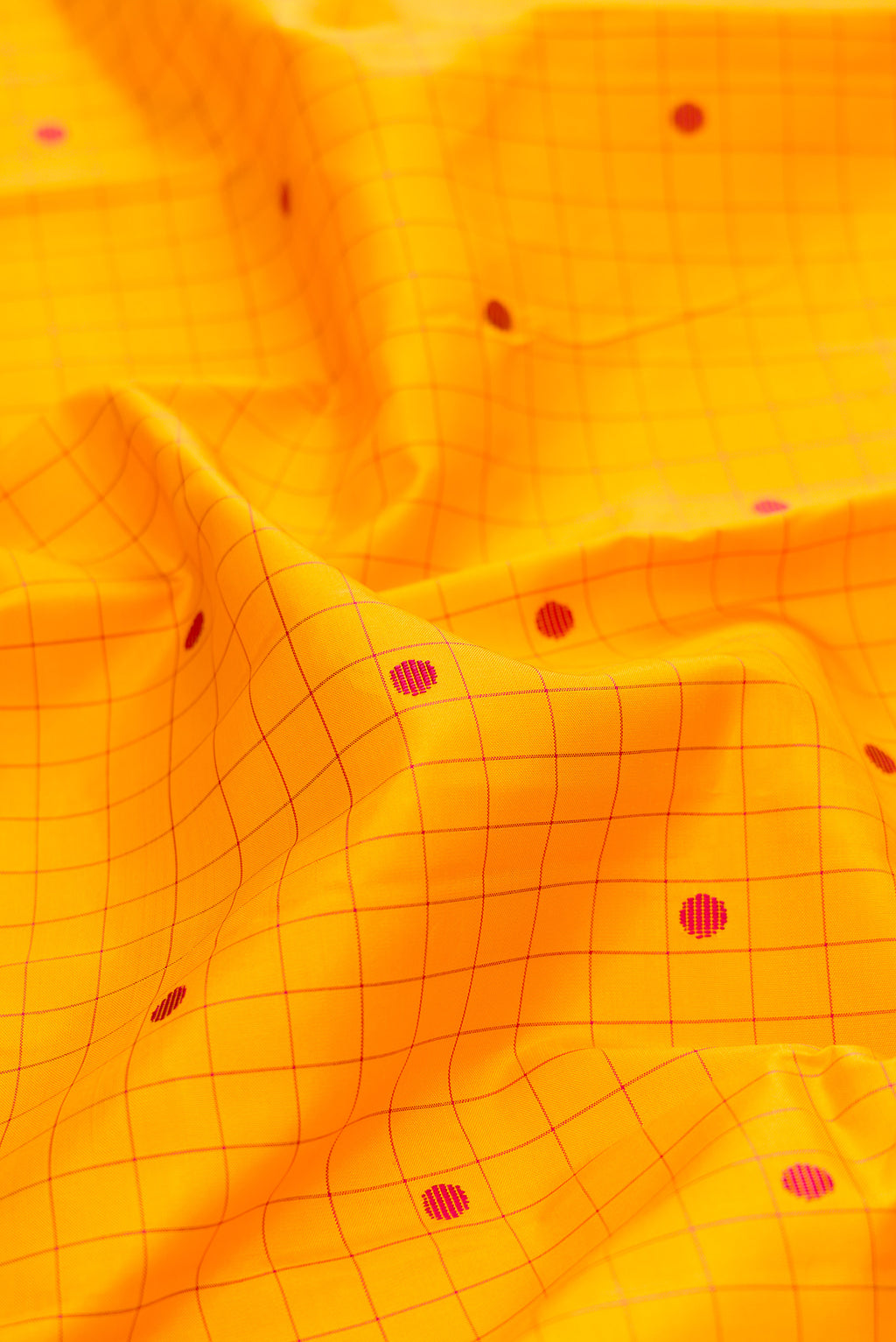 Close up of Pure Silk Yellow Kanjivaram Saree with Checked design on the body and Plain Border.  displaying folds