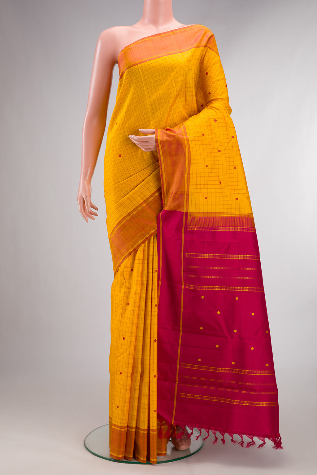 Pure Silk Yellow Kanjivaram Saree with Checked design on the body and Plain Border.  displayed on a mannequin