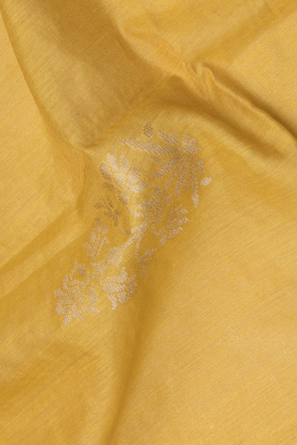 Close up of Pure Silk Yellow Tussar Saree with Zari Butta on the body and Embroidered Border.  displaying folds