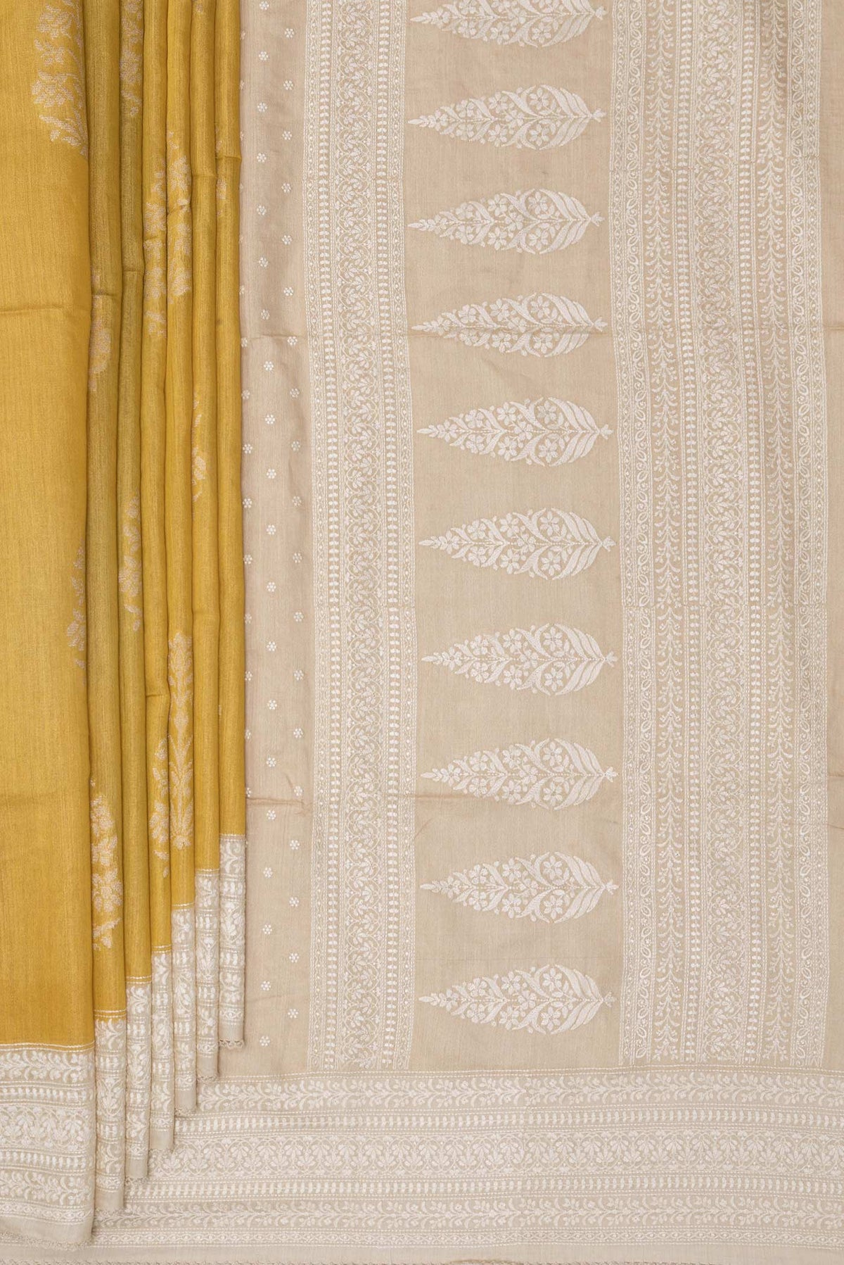 Pleats and pallu of Pure Silk Yellow Tussar Saree with Zari Butta on the body and Embroidered Border. 