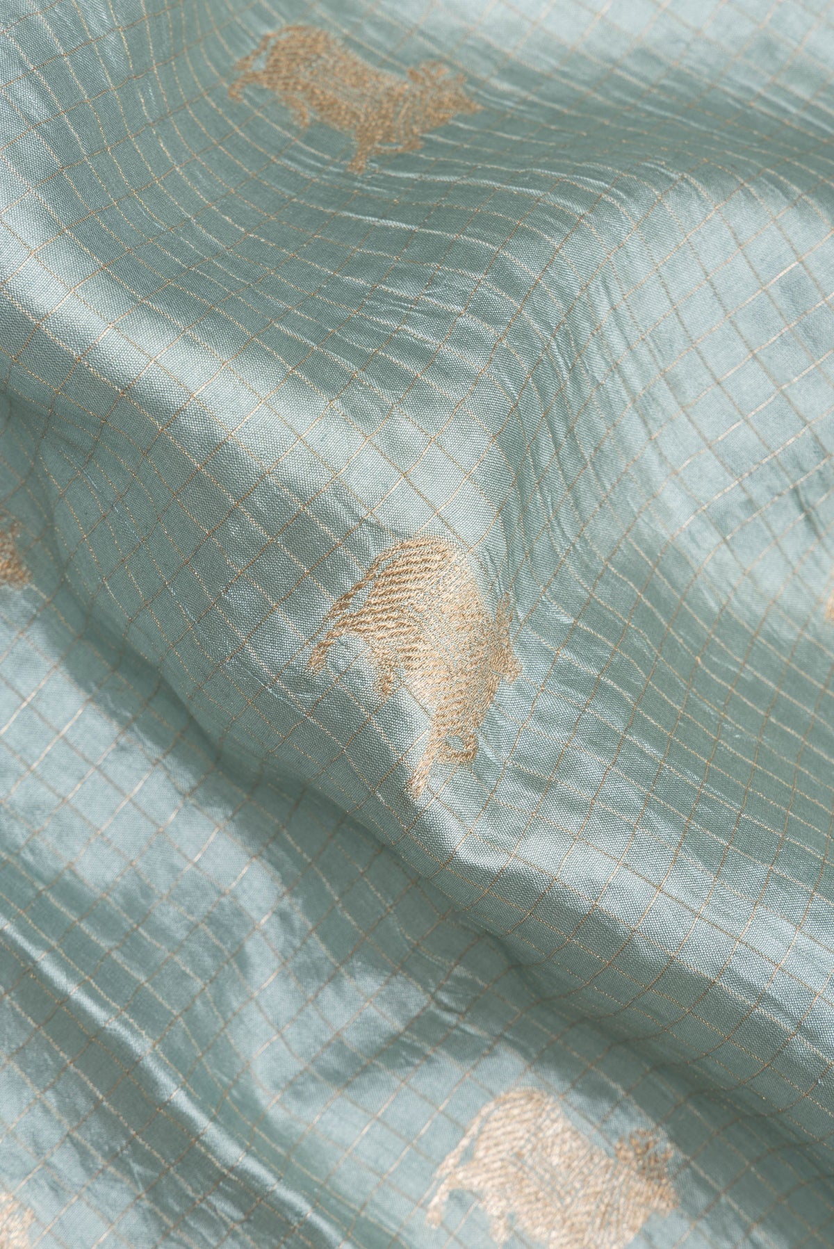 Close up of Pure Silk Light Blue Tussar Saree with Checked design on the body and Embroidered Border.  displaying folds
