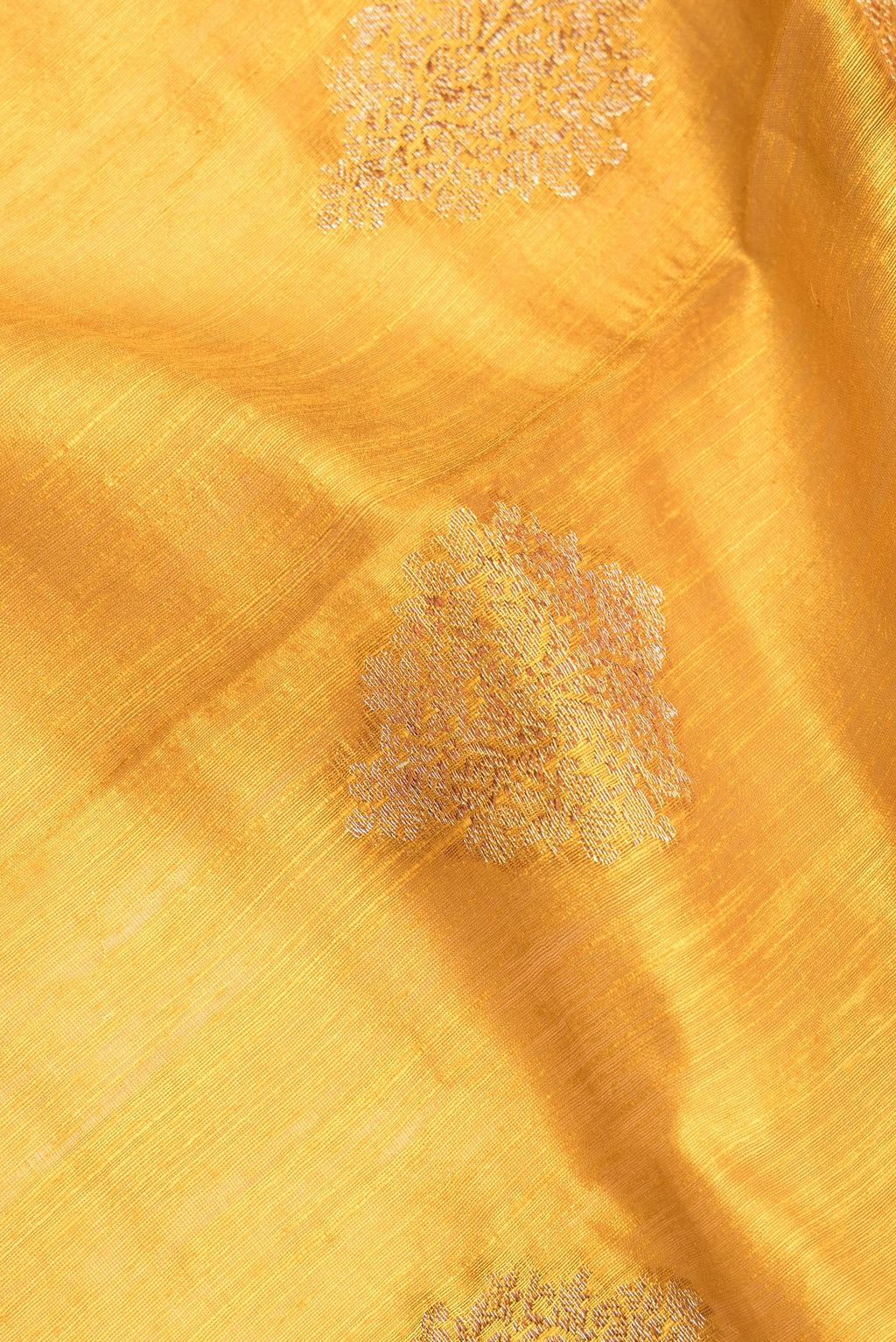 Close up of Yellow Raw Saree with Zari Butta on the body and Zari Border.  displaying folds
