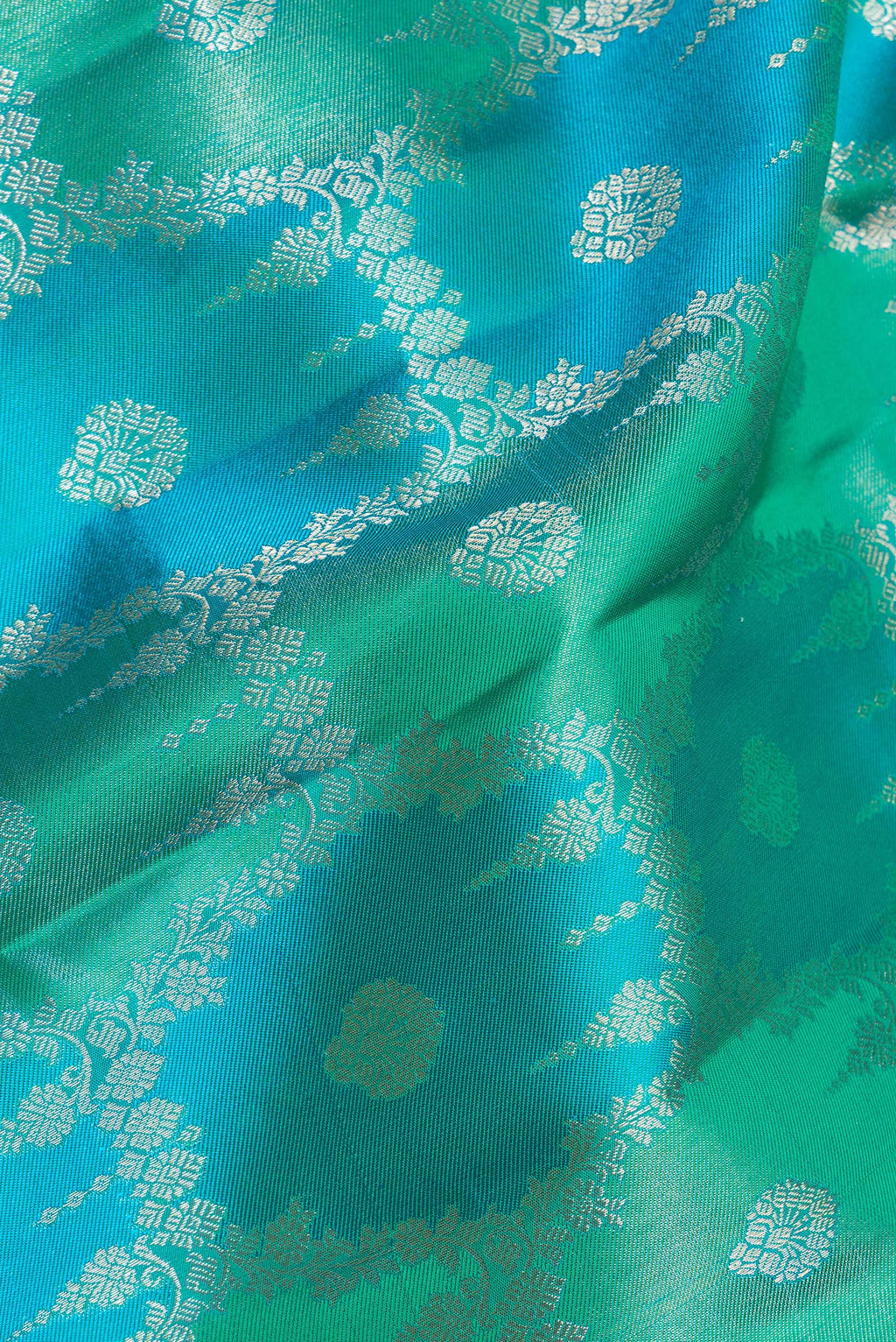 Close up of Pure Silk Sea Green and Peacock Blue Color Kanjivaram Saree with Zari Brocade on the body and Zari Border.  displaying folds