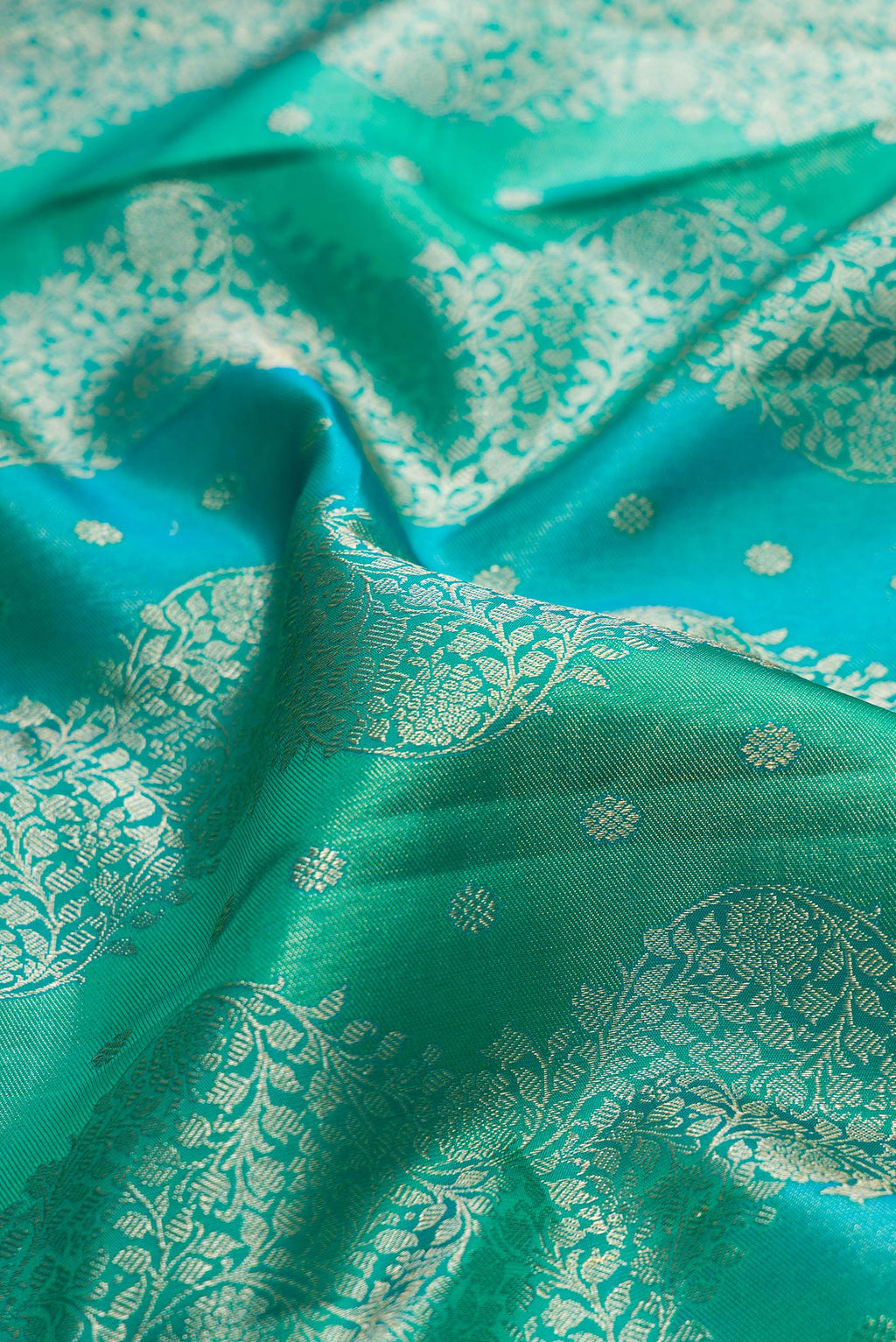 Close up of Pure Silk Sea Green Dual Tone Kanjivaram Saree with Zari Brocade on the body and Zari Border.  displaying folds