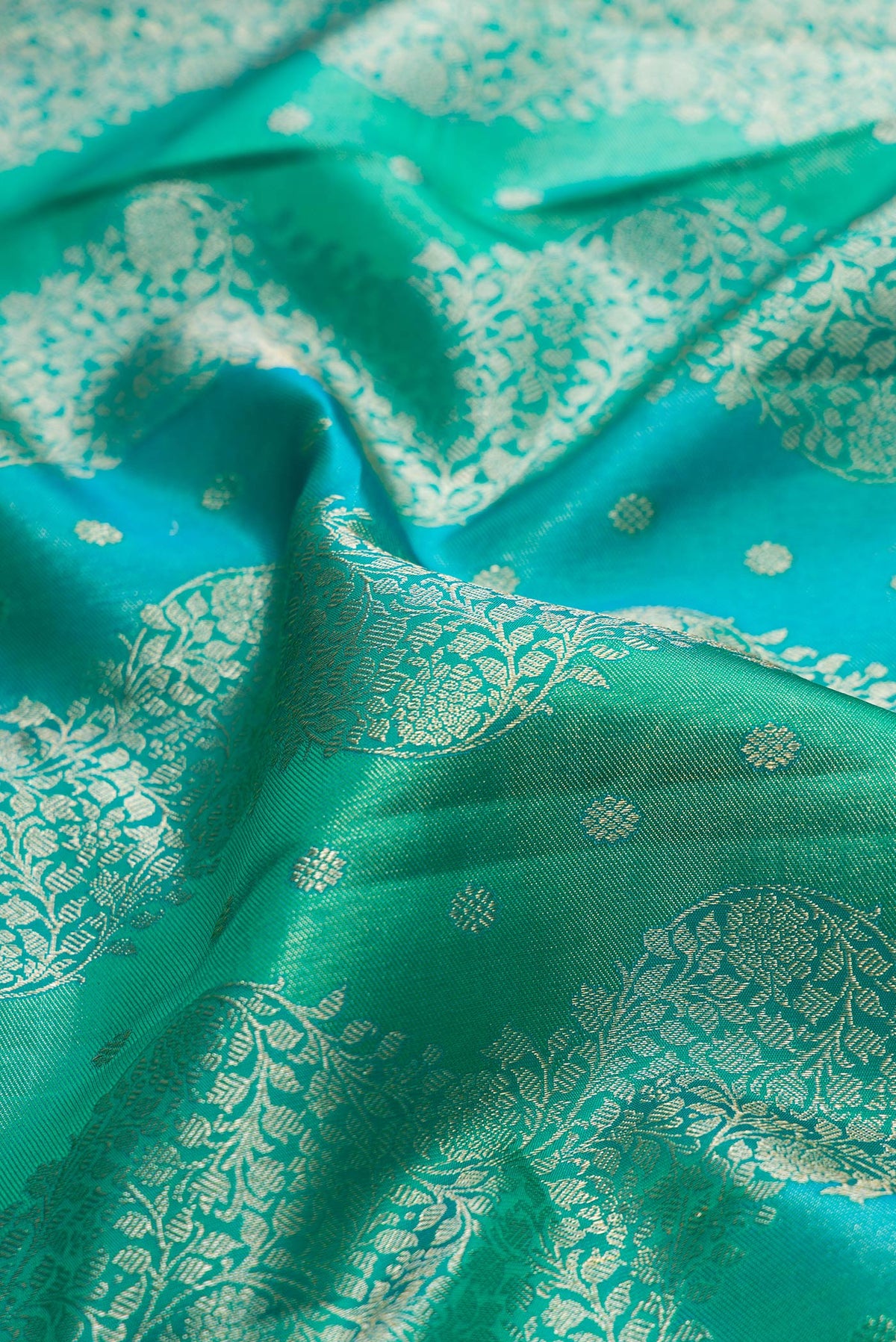 Close up of Pure Silk Sea Green Dual Tone Kanjivaram Saree with Zari Brocade on the body and Zari Border.  displaying folds