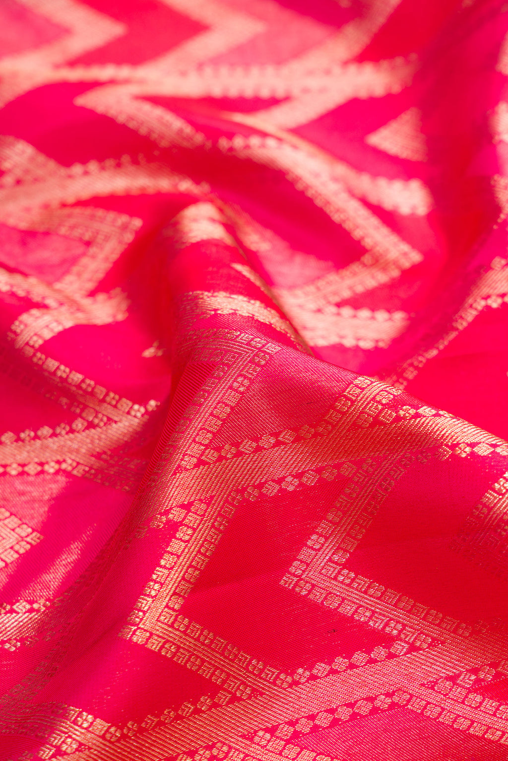 Close up of Pure Silk Dark Pink Kanjivaram Saree with Zari Brocade on the body and Zari Border.  displaying folds