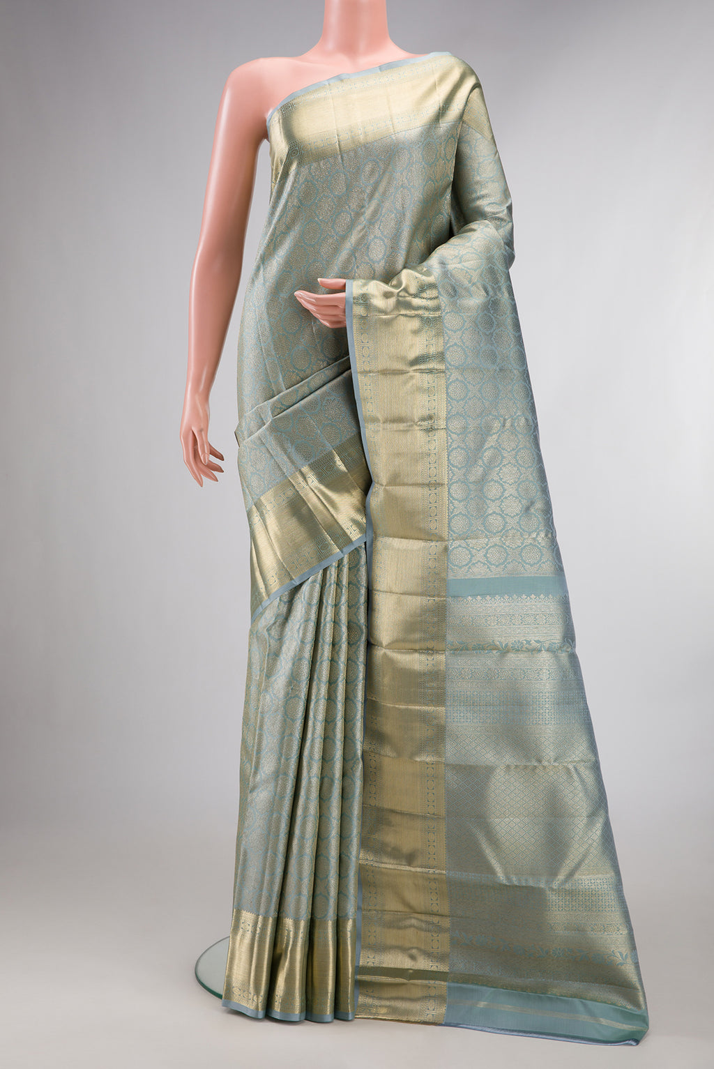 Pure Silk Grey Kanjivaram Saree with Zari Brocade on the body and Zari Border.  displayed on a mannequin