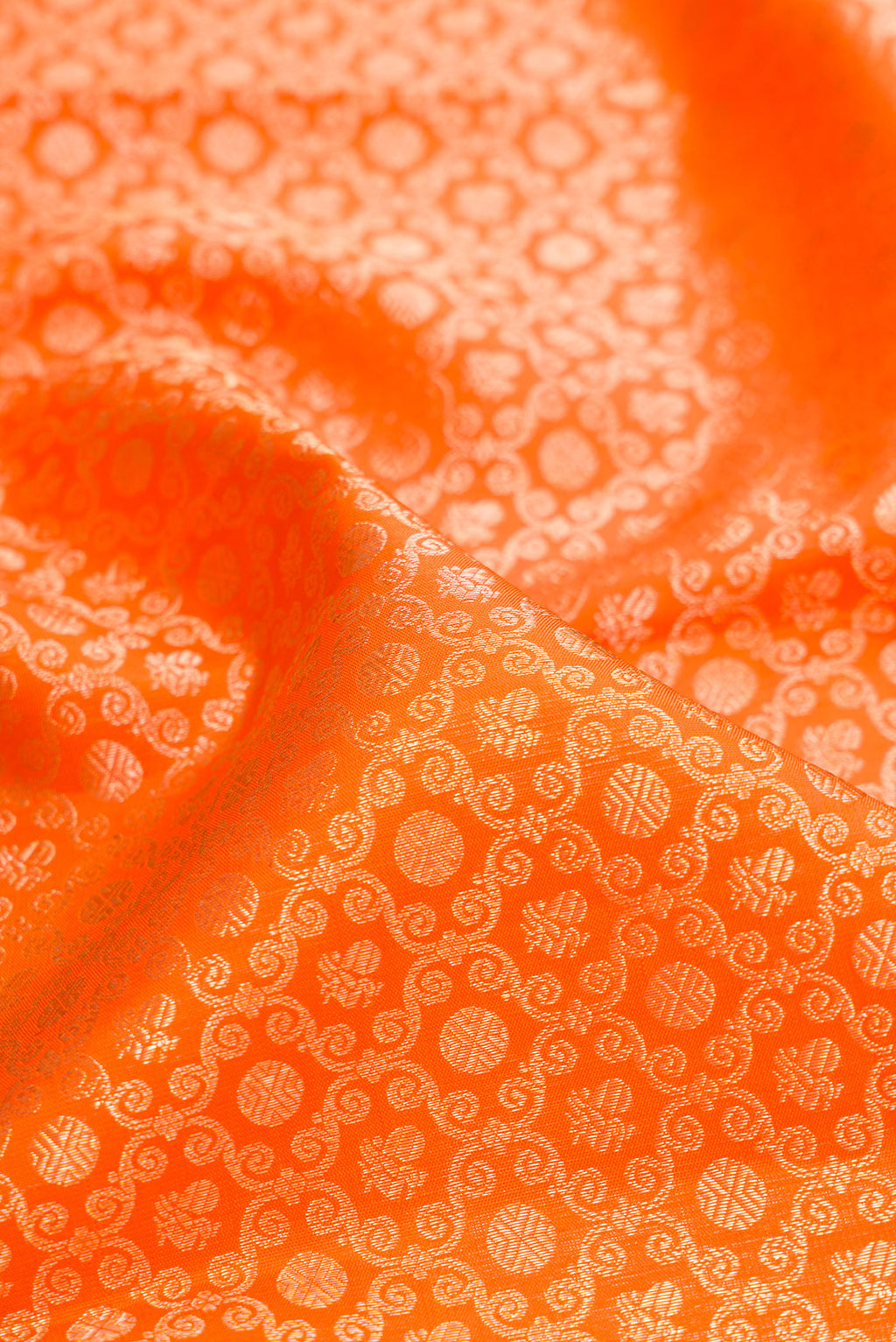 Close up of Pure Silk Orange Kanchipuram Saree with Zari Brocade on the body and Fancy Border.  displaying folds